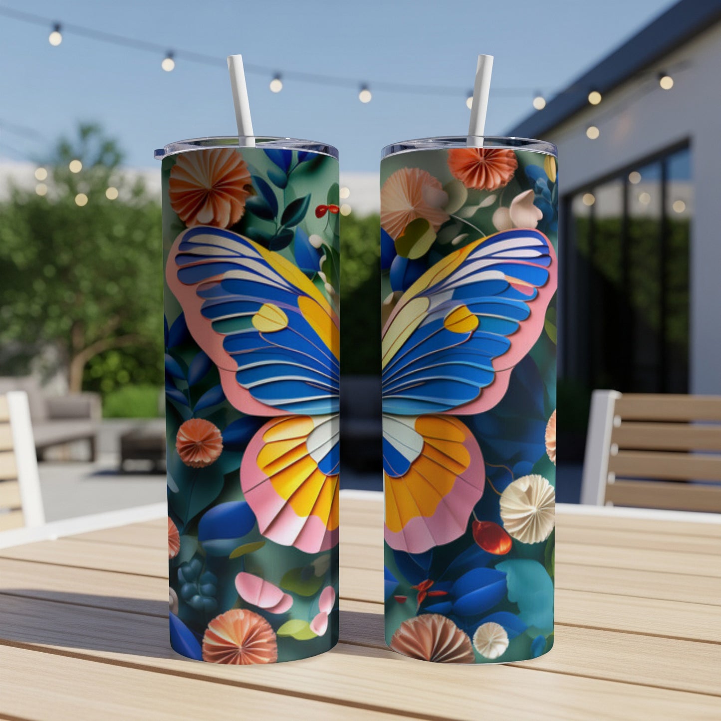 Two tumblers featuring a colorful butterfly design on a table outdoors.