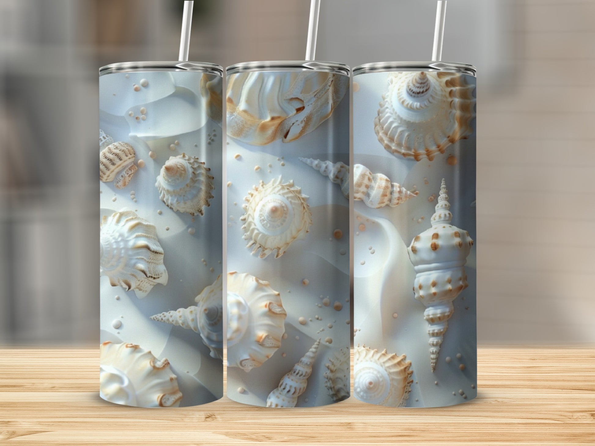 Three tall tumblers featuring detailed seashell patterns on a wooden surface.