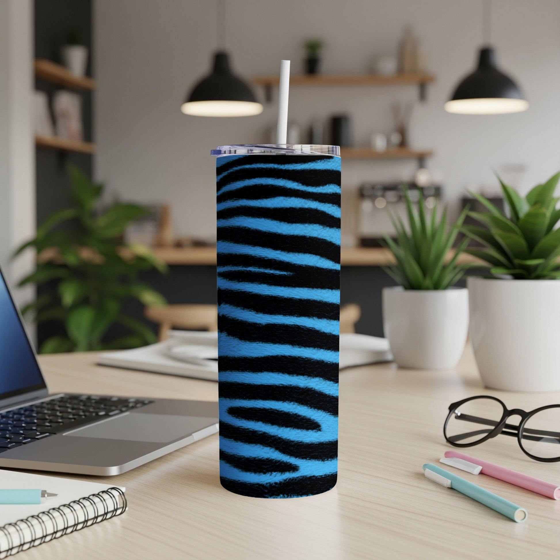 Tall tumbler with blue and black tiger stripes featuring a white straw.