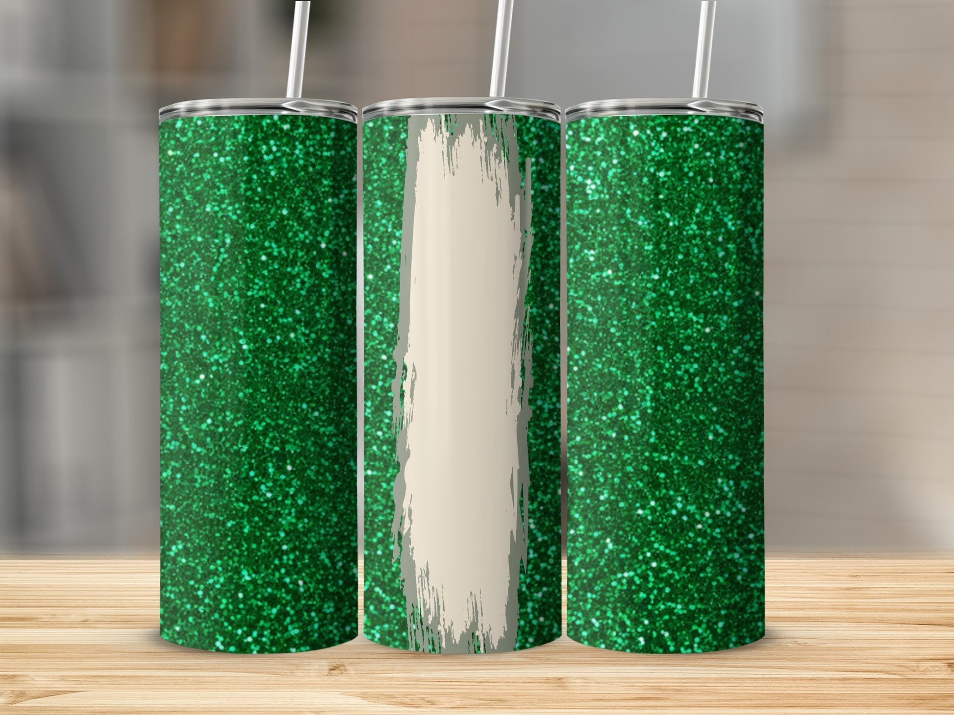Three green glitter tumblers with straw on a wooden surface.