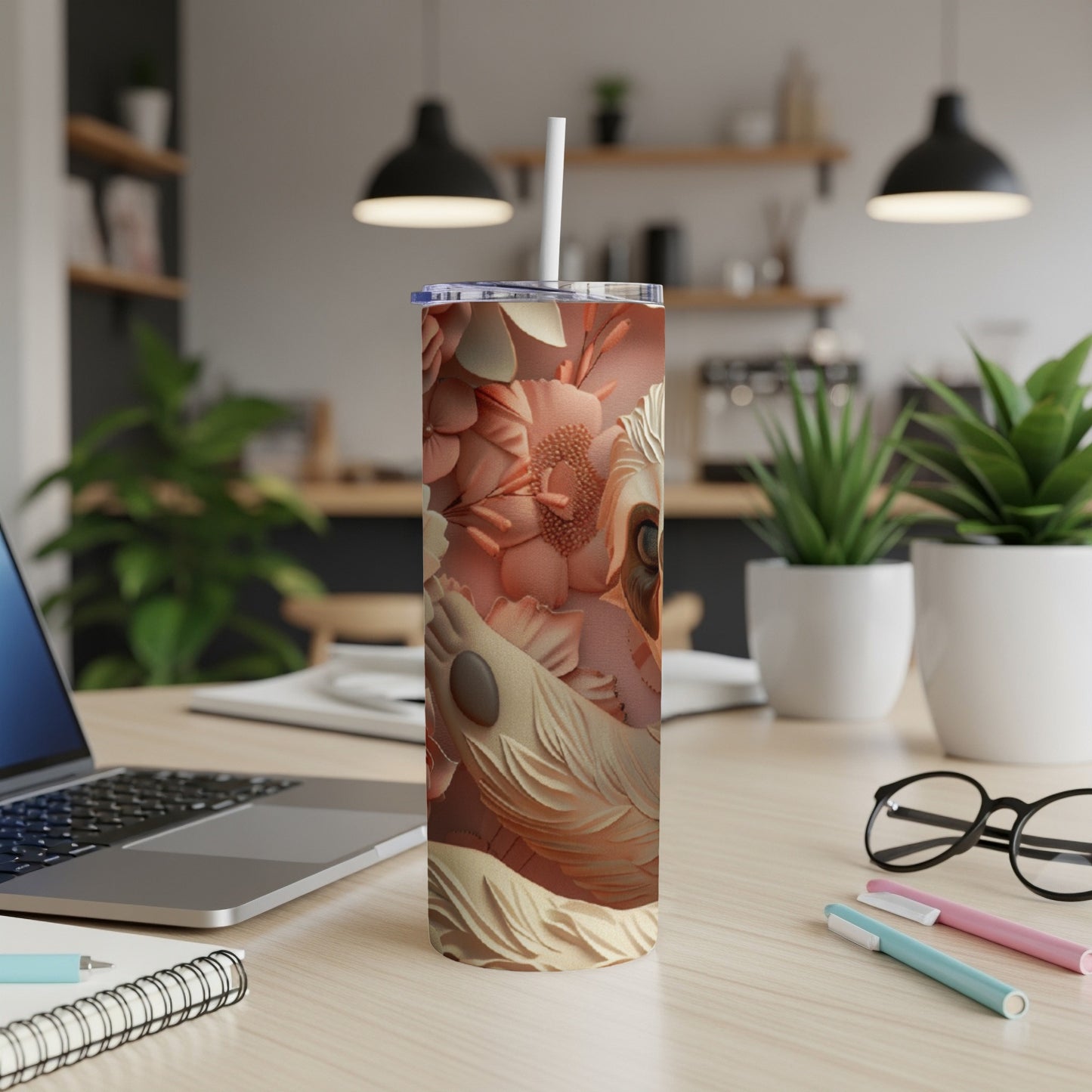 Floral pattern tumbler with a dog's face on a desk with a laptop.