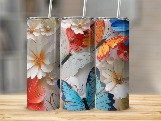 Three tumblers with floral and butterfly designs on a wooden surface.