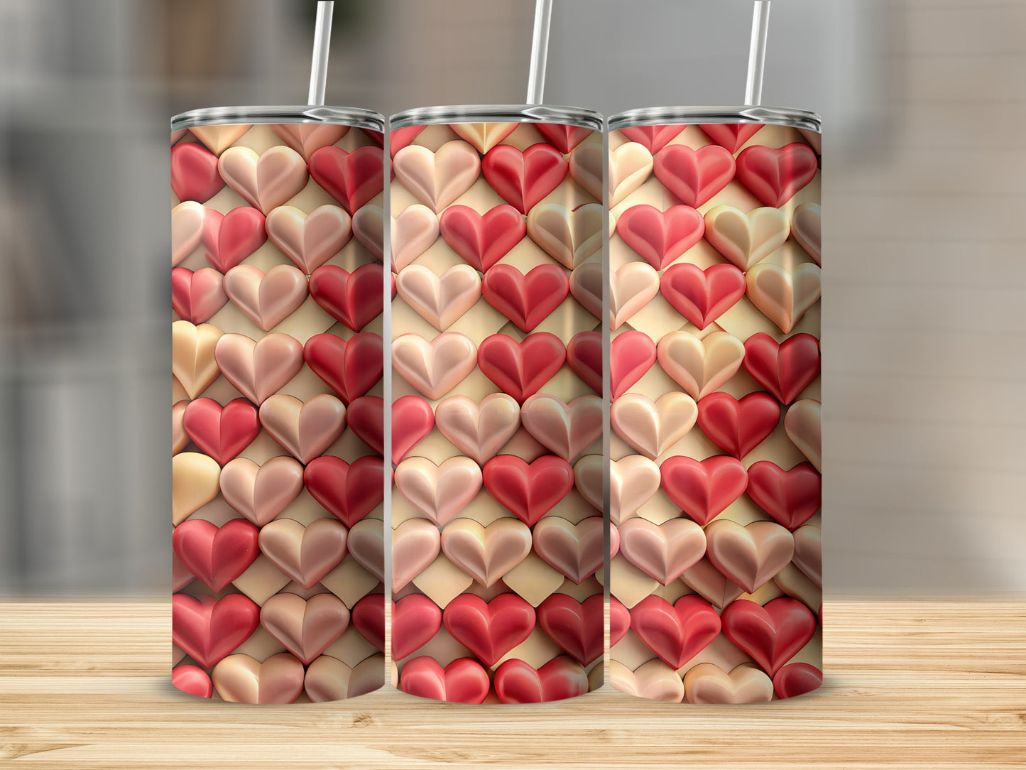 Three tumblers with a repeating heart pattern in shades of pink and red.