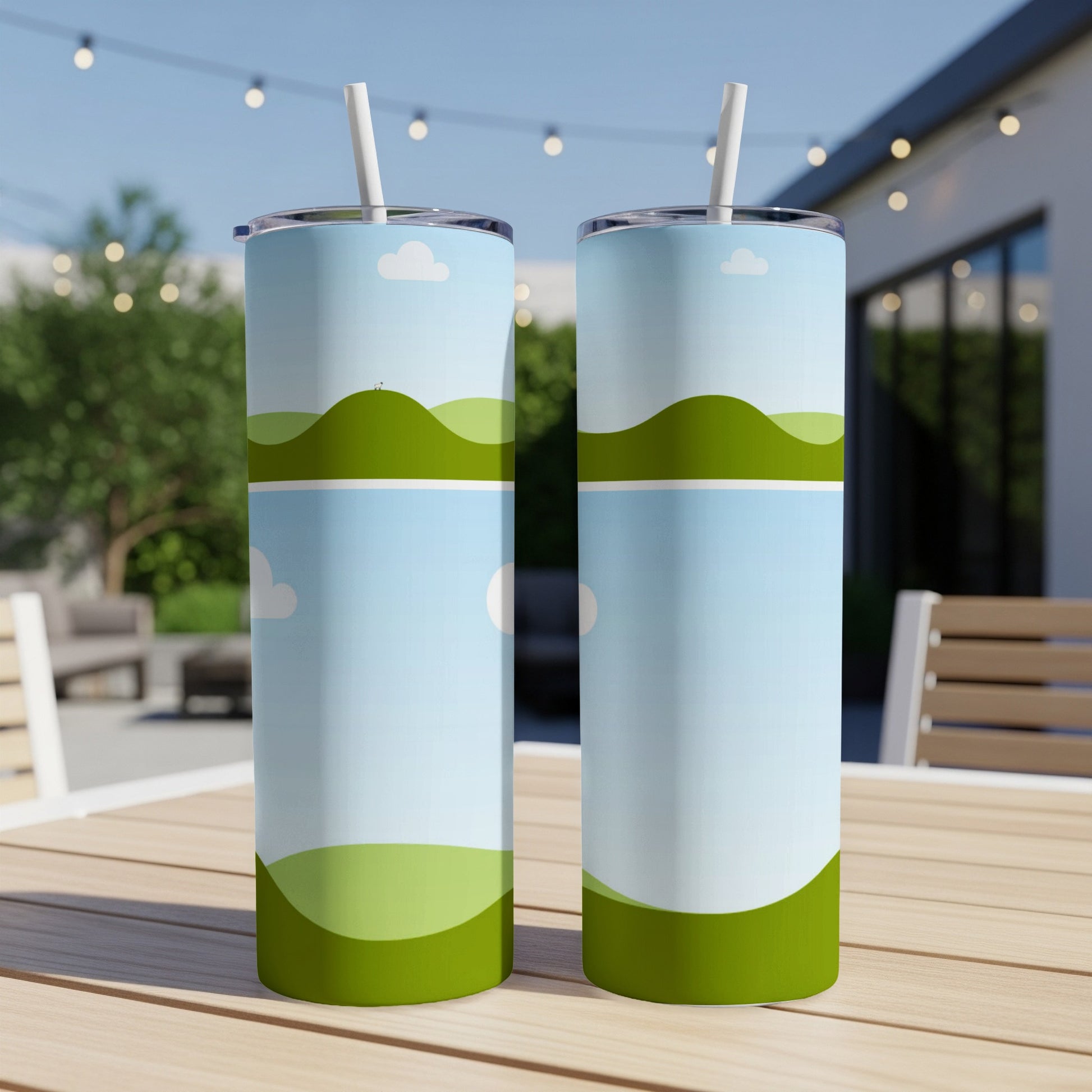 Two tumblers with a cartoon landscape design on a wooden table.