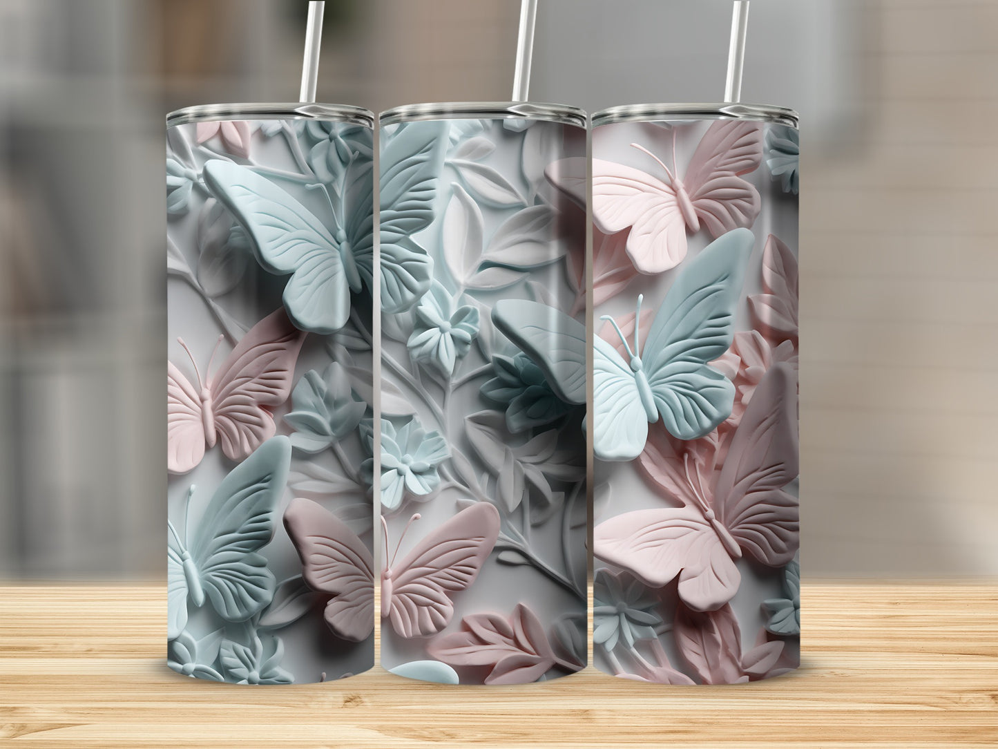Three tumblers with embossed butterflies and floral designs.