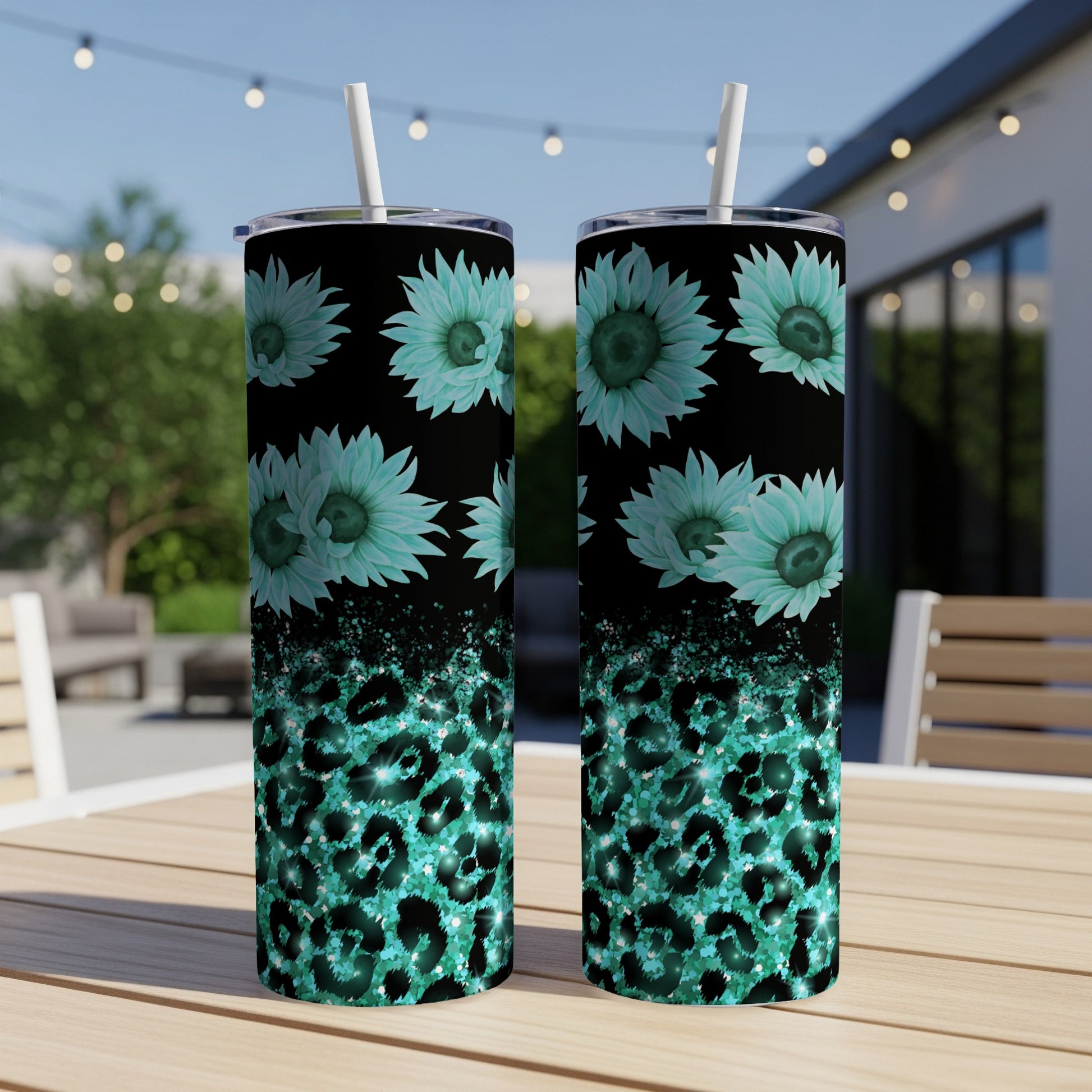 Two teal tumblers with leopard print and floral designs on an outdoor table.