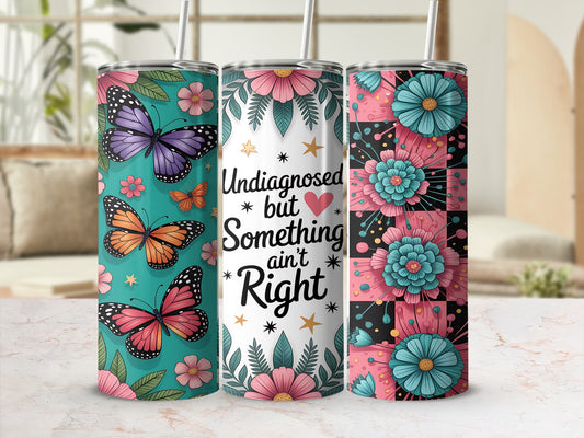 Three tumblers featuring butterflies, flowers, and text that reads "Undiagnosed but Something ain't Right".