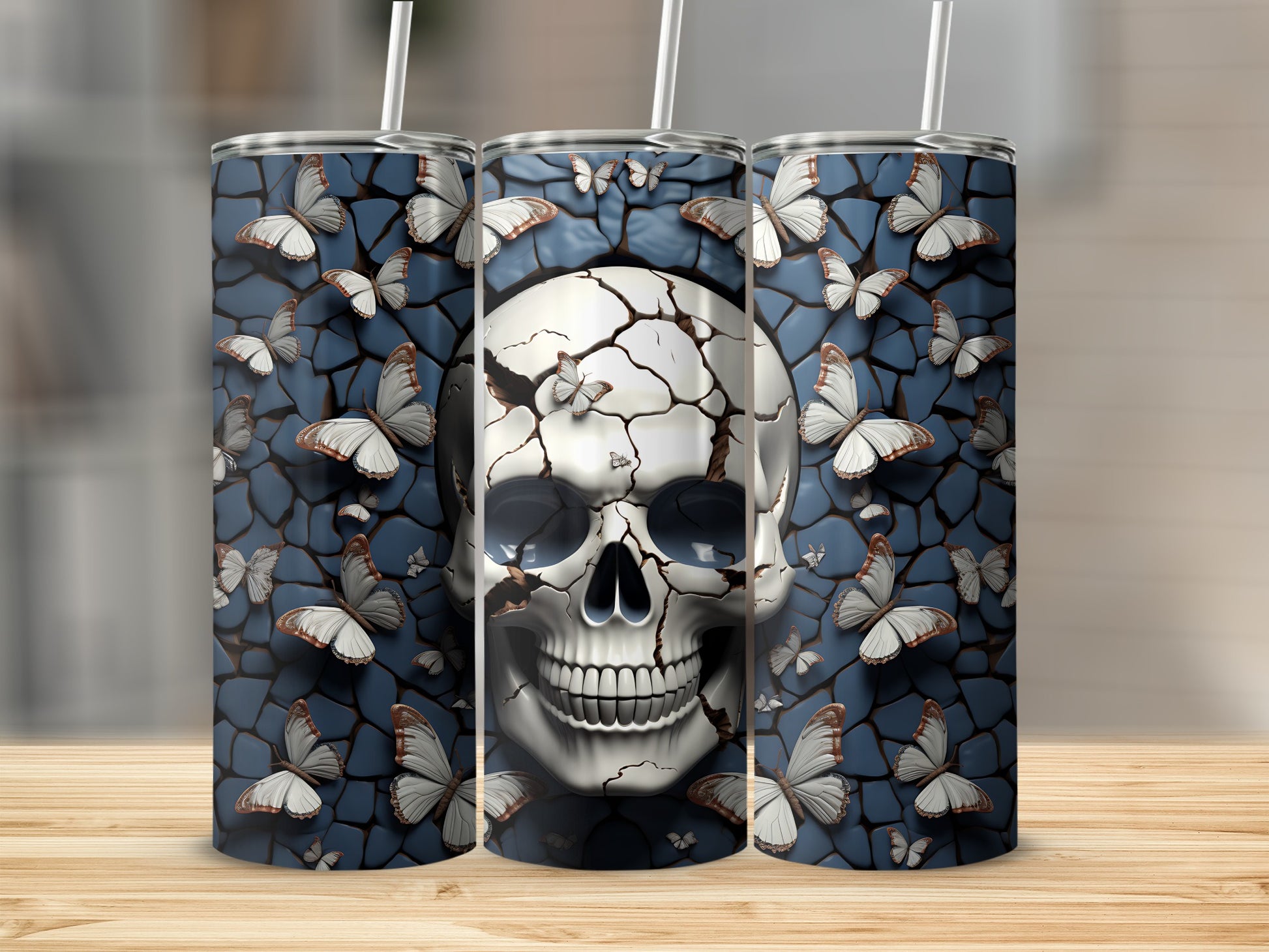 Cracked skull with butterflies on a patterned blue background, shown on three tumblers.