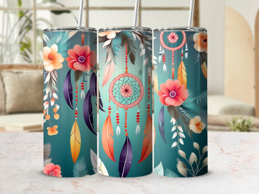 Three tumblers with floral and dreamcatcher designs on a marble surface.