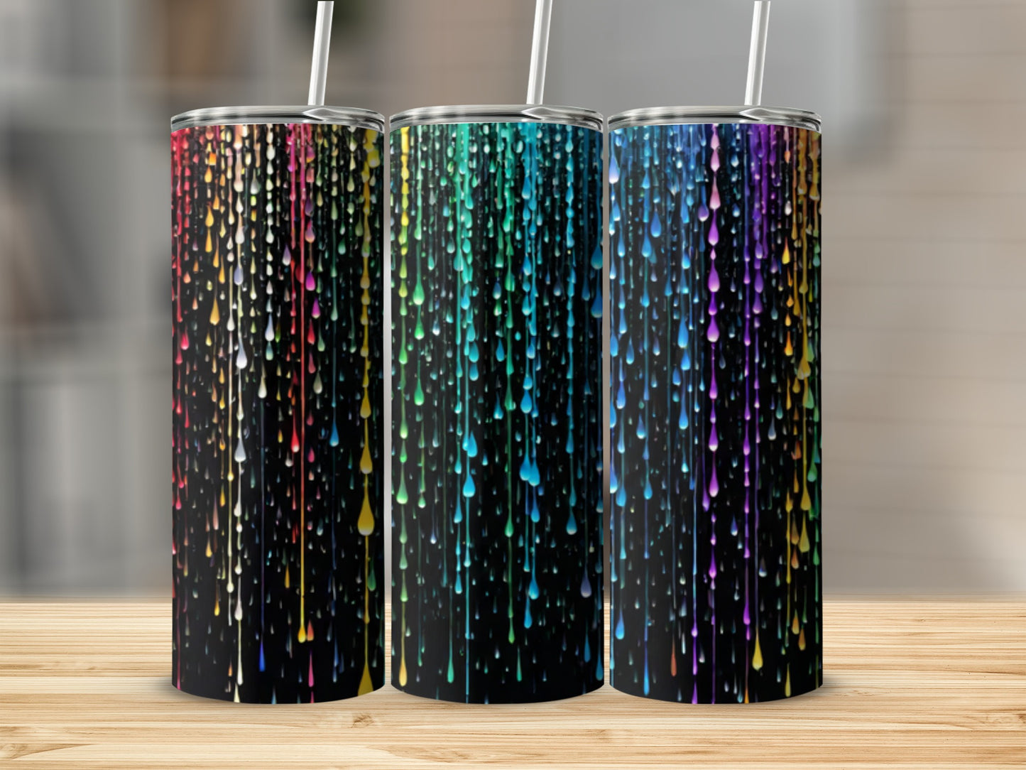 Three black tumblers with colorful dripping paint design and straws.