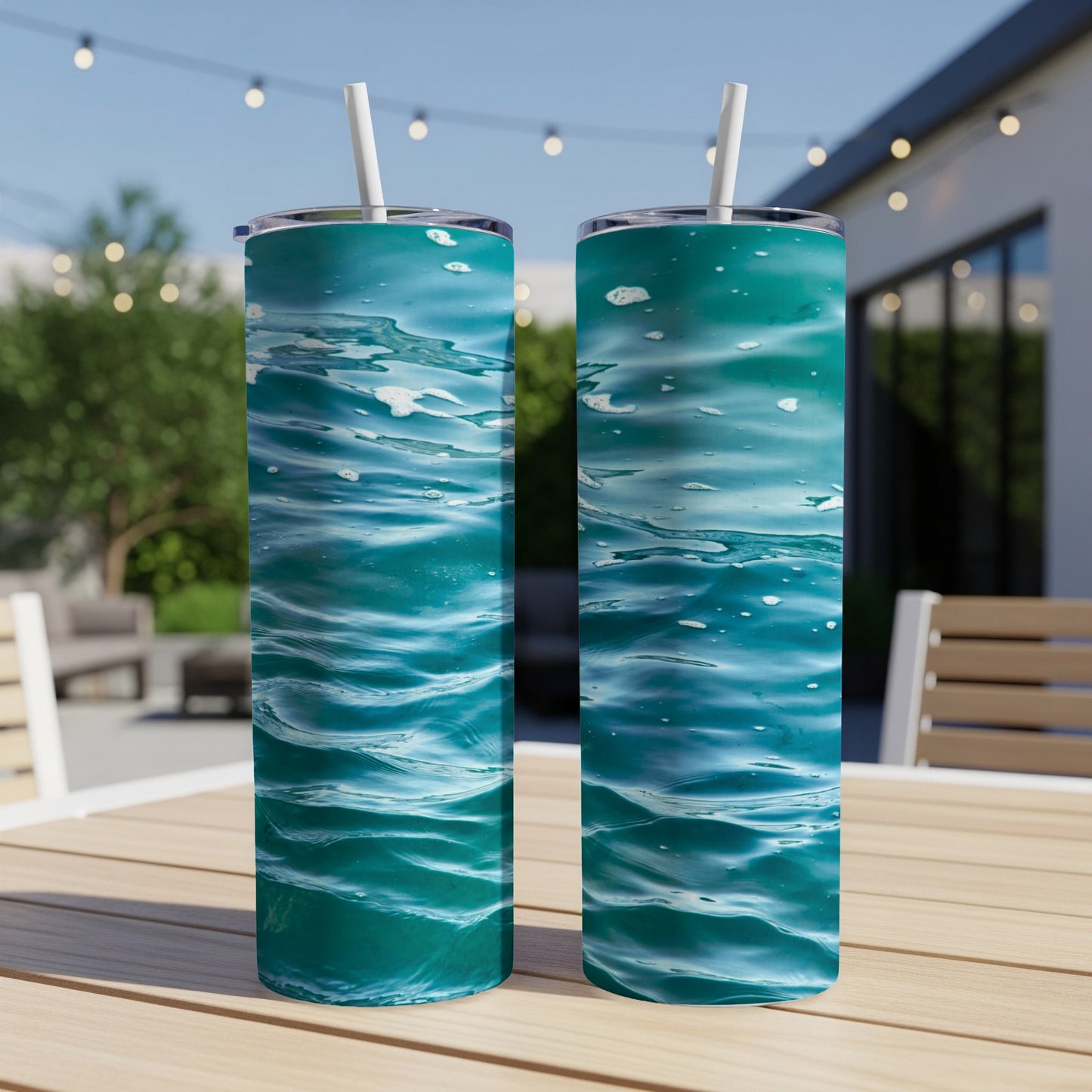 Two teal tumblers with a water ripple design on a wooden table.