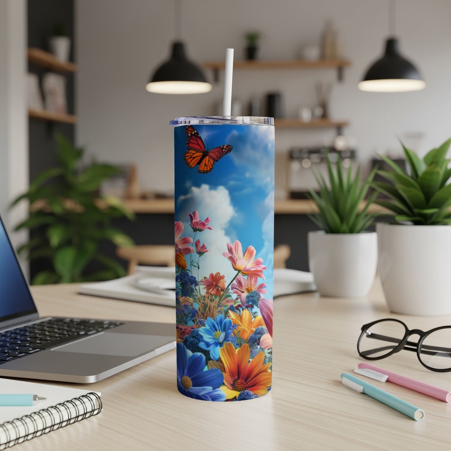 Butterfly and wildflowers on a blue sky tumbler with a white straw.