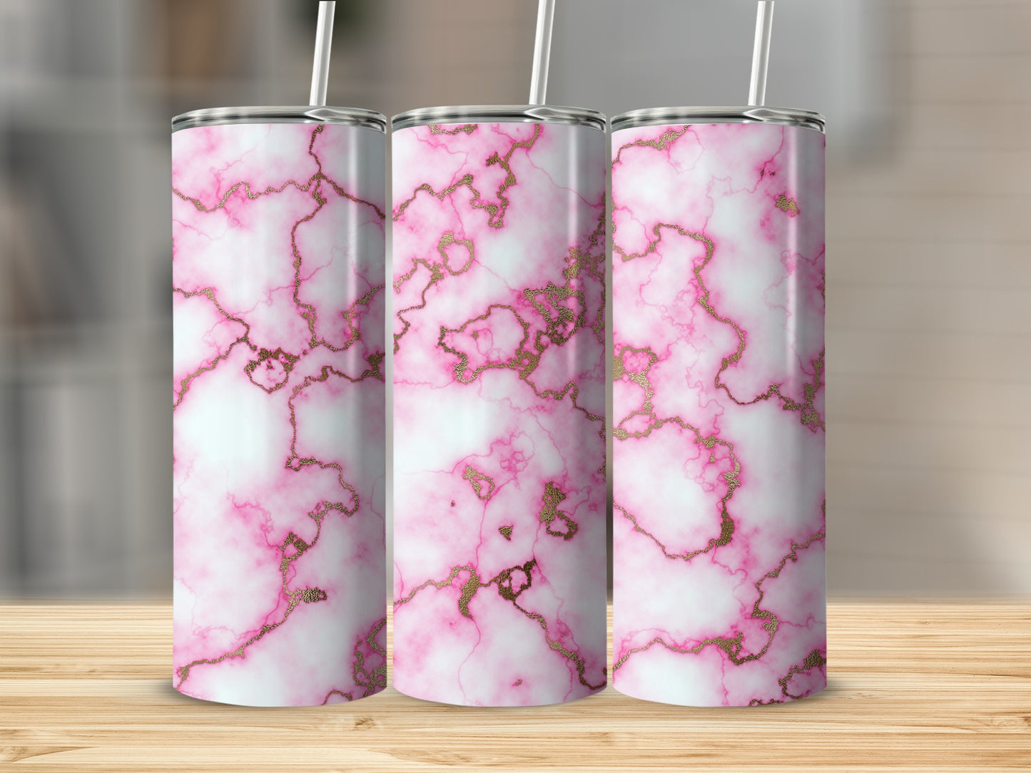 Three pink and white marble tumblers with gold veining on a wooden surface.