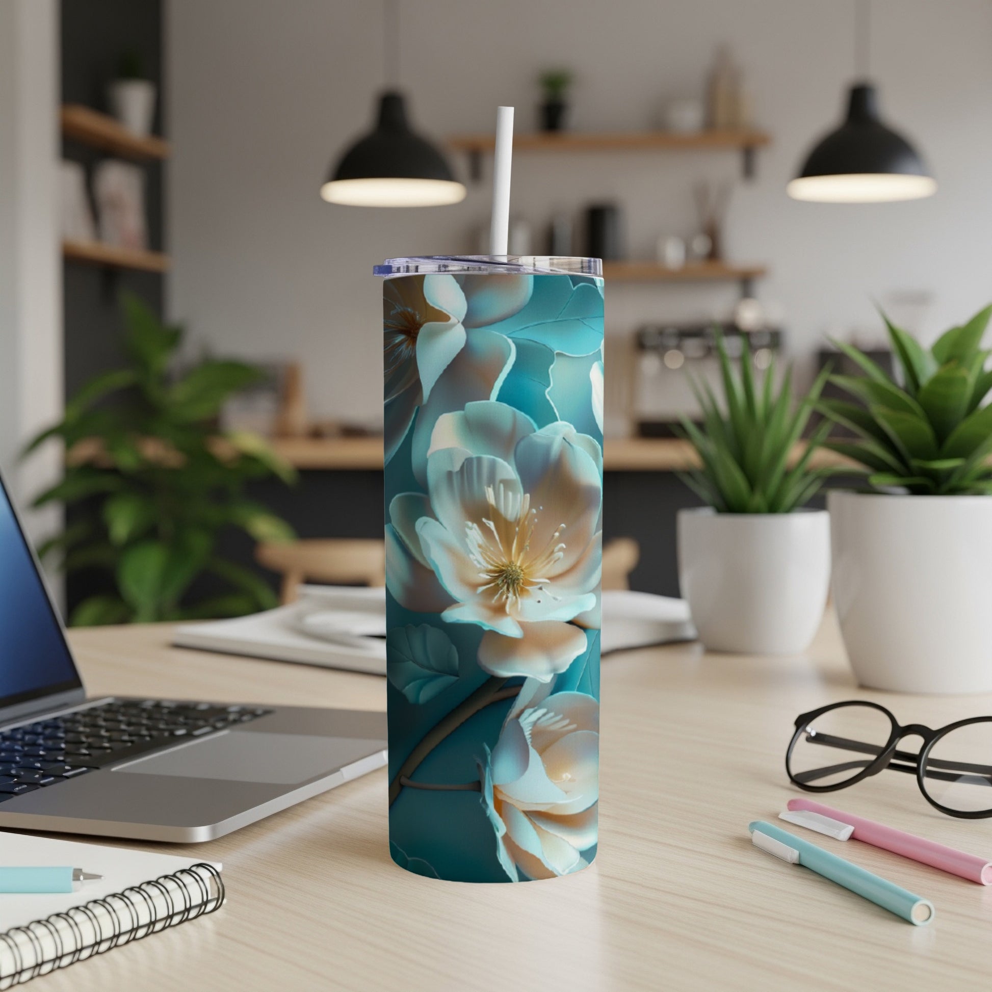 Floral patterned tumbler with lid and straw on a wooden desk.