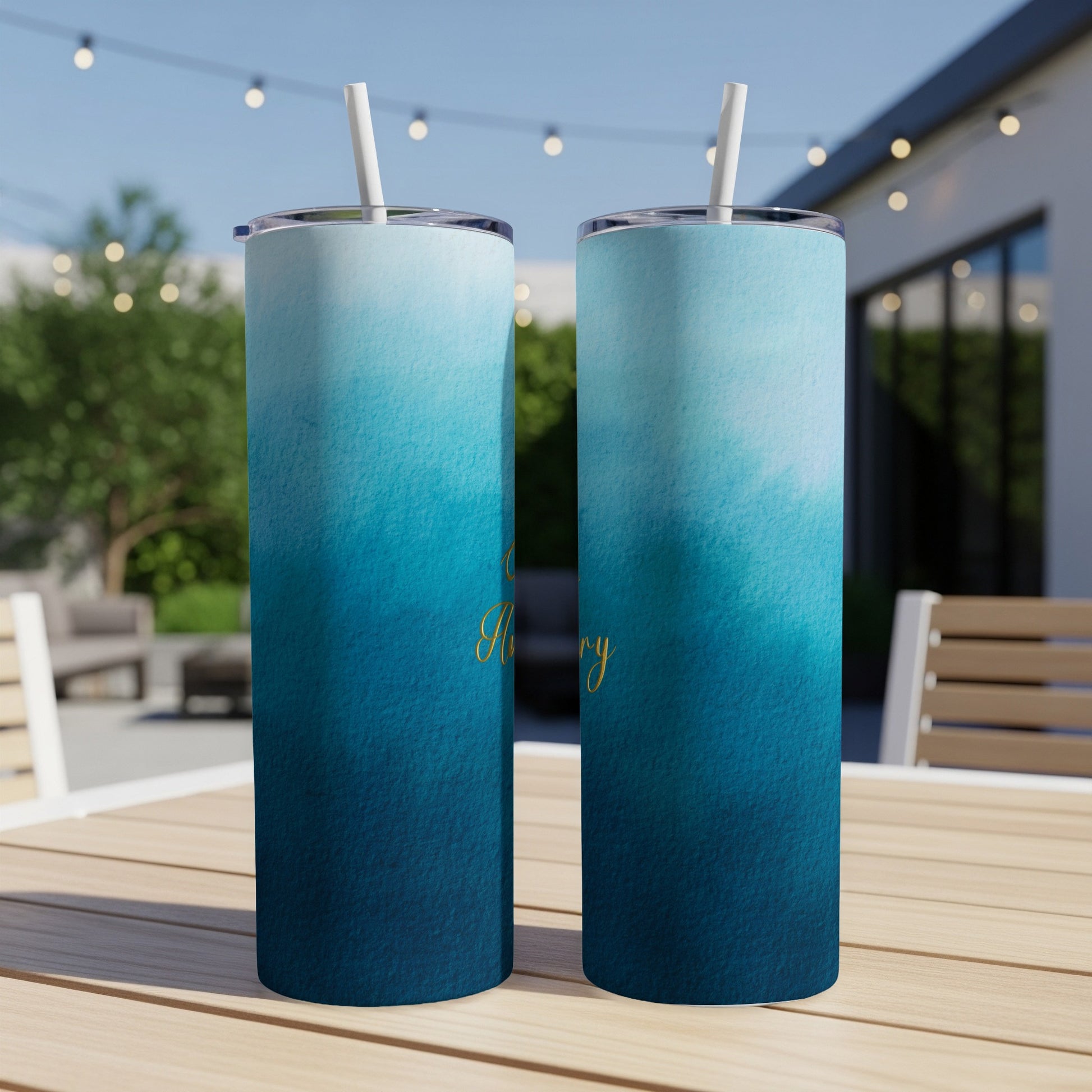 Two tall tumblers with a blue watercolor gradient design and gold script text.