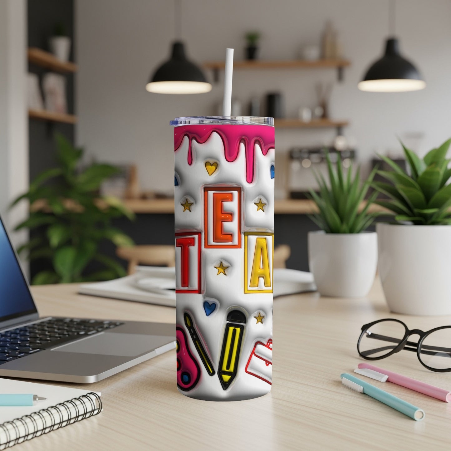 Tumbler with "TEA" in raised letters, art supplies, and pink drips.