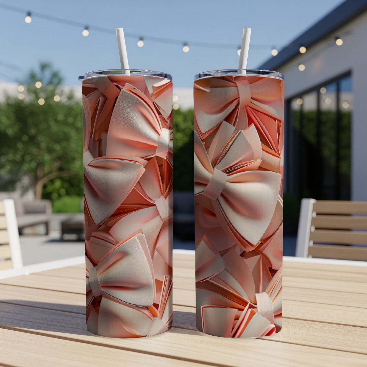 Two tall tumblers with a repeating pattern of shiny, rose gold bows.