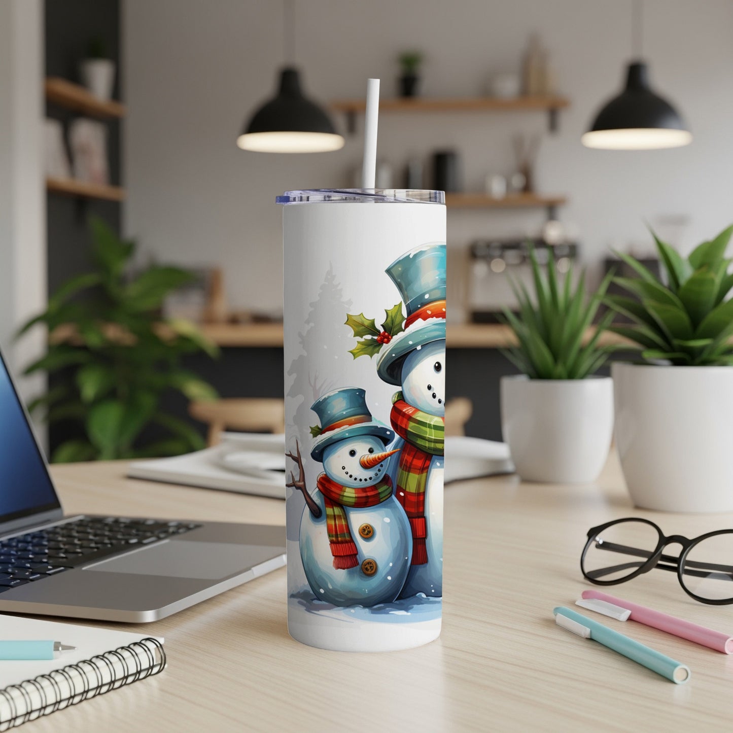 Two cartoon snowmen with scarves and hats on a white tumbler cup.