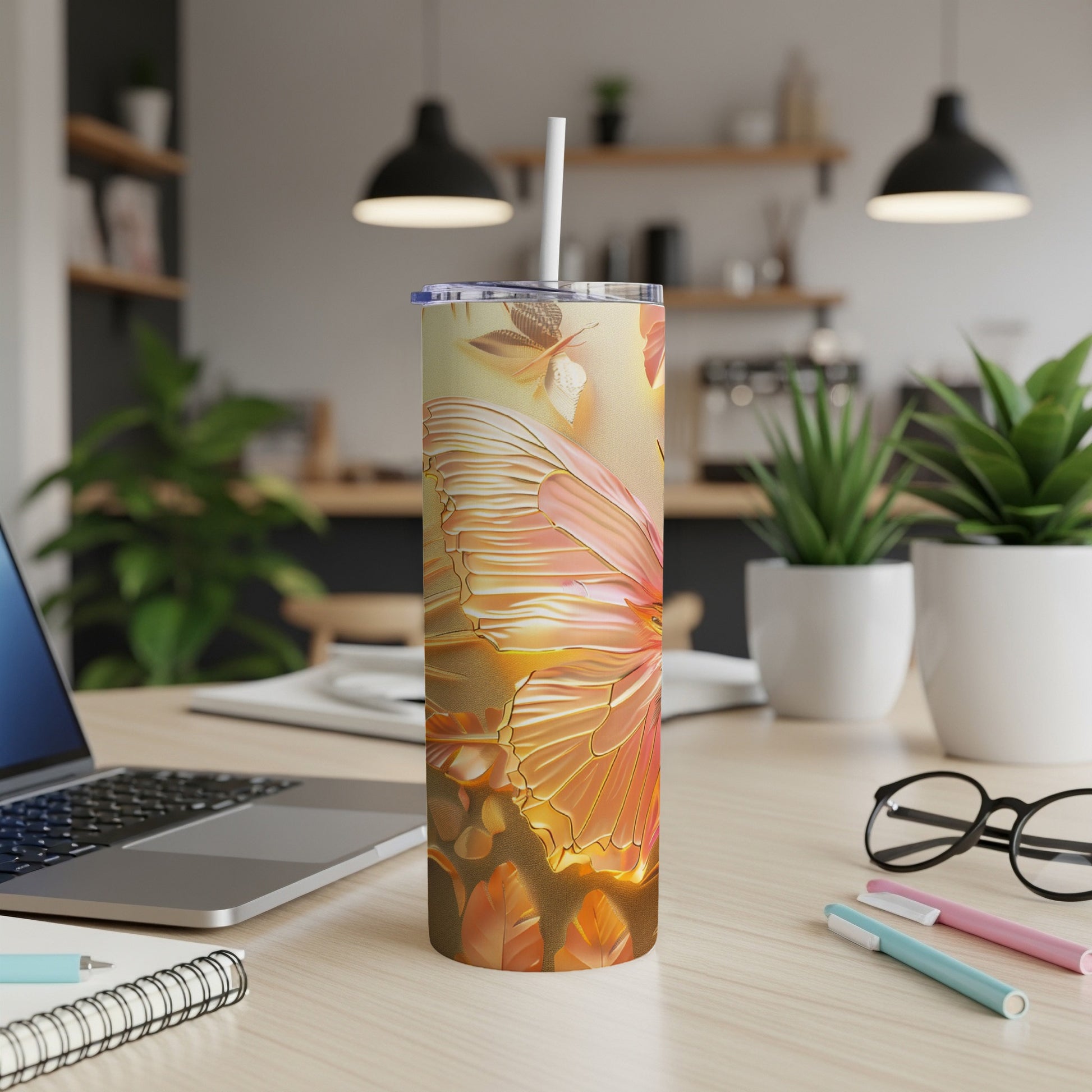 Butterfly print tumbler with lid and straw on a desk.