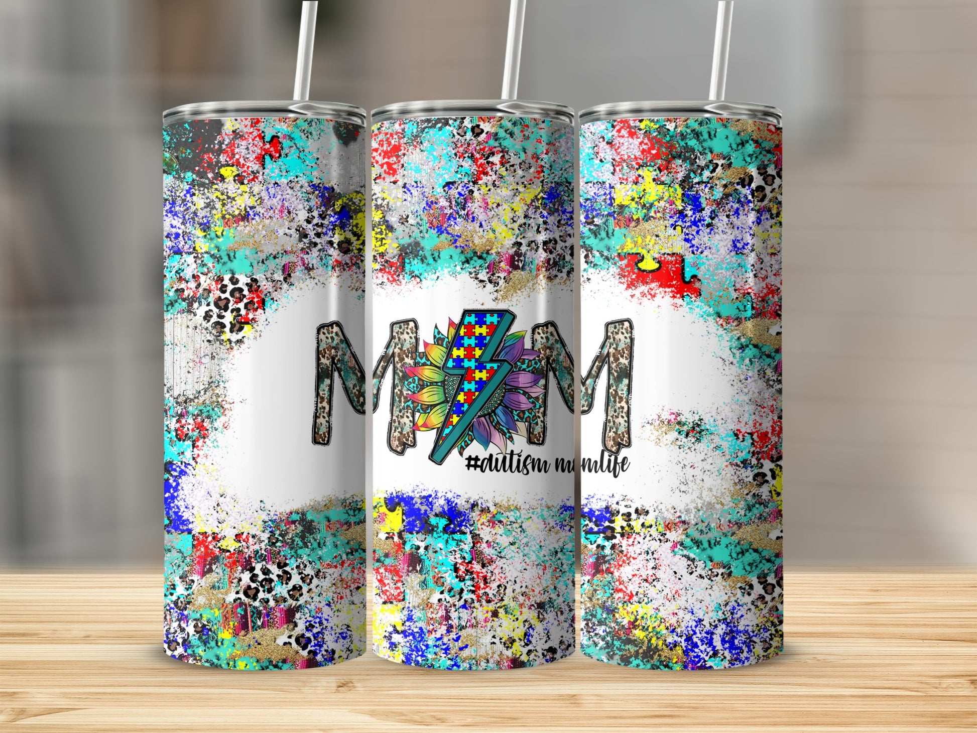 Three tumblers with colorful paint splatters and "Autism Mom Life" text.