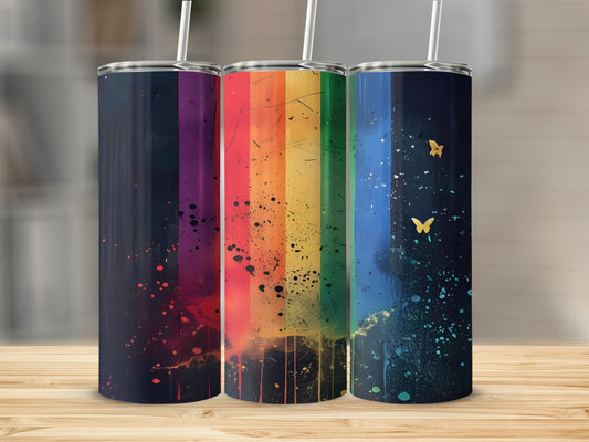 Three tumblers with rainbow and butterfly designs on a wooden surface.