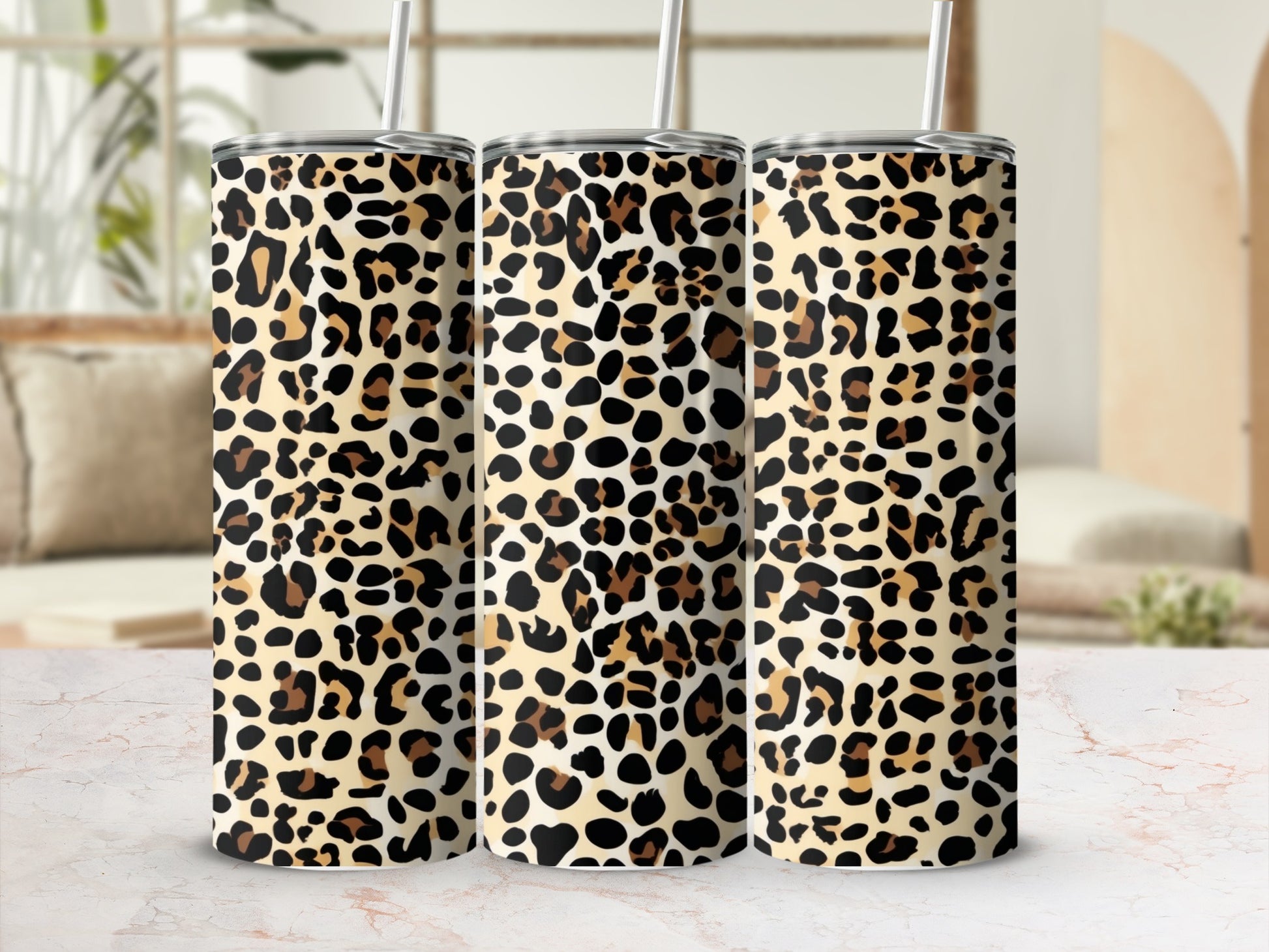 Three tumblers with a leopard print pattern sit on a marble surface.