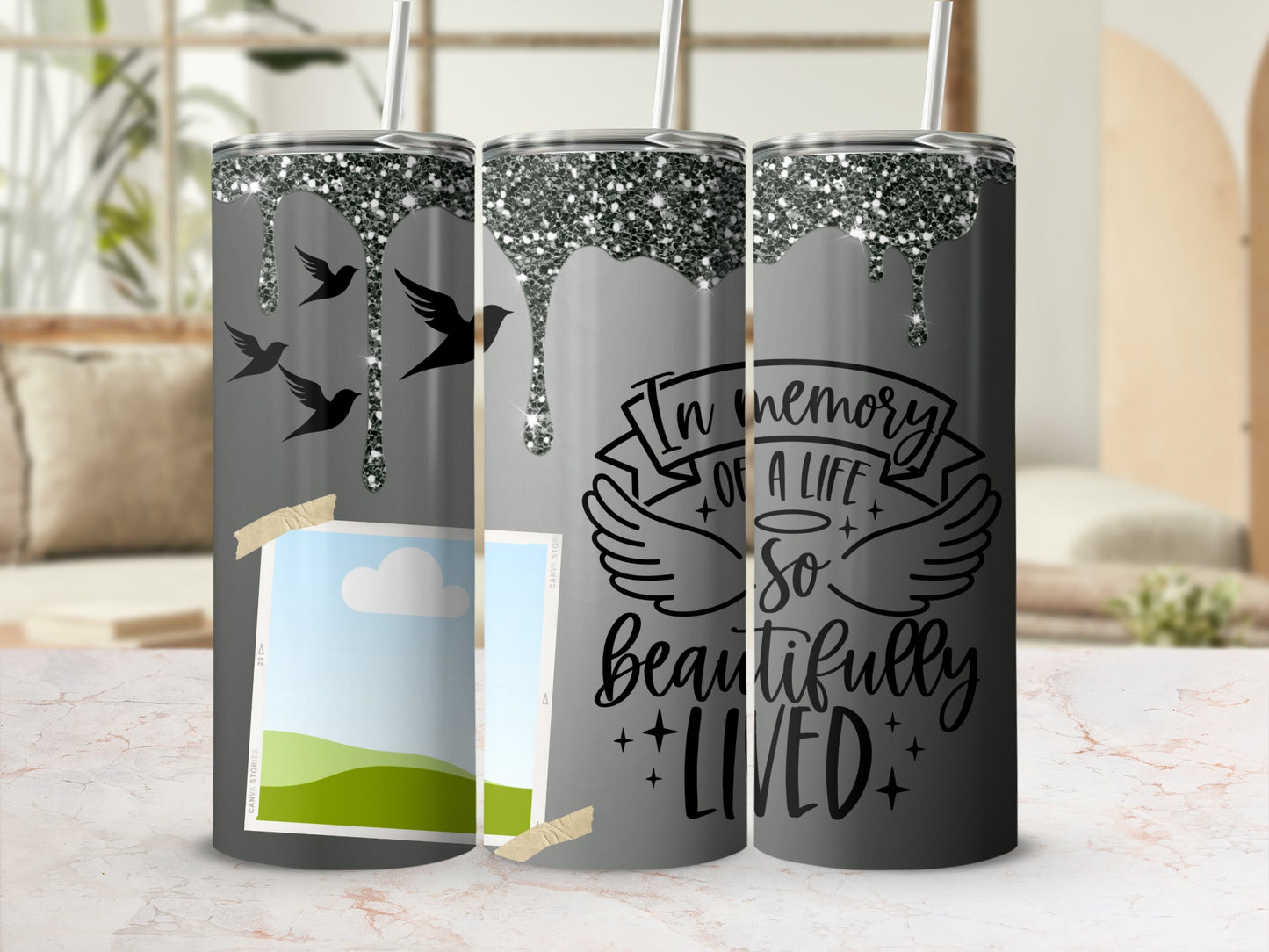 Gray tumbler with dripping glitter and birds, saying "In memory of a life so beautifully lived."