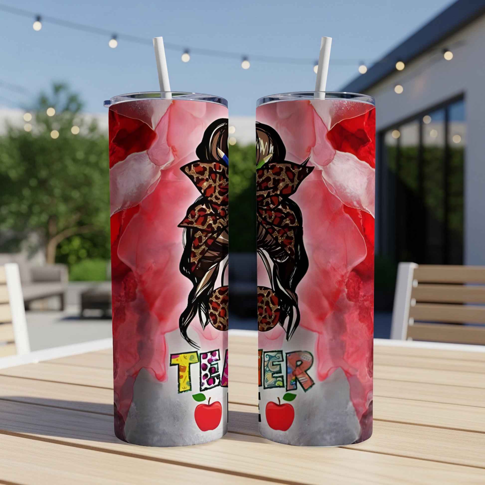 Two teacher-themed tumblers with apple and leopard print accents on a table.