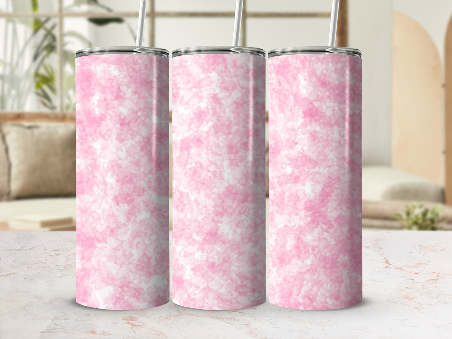 Three pink marble patterned tumblers with straws on a marble surface.