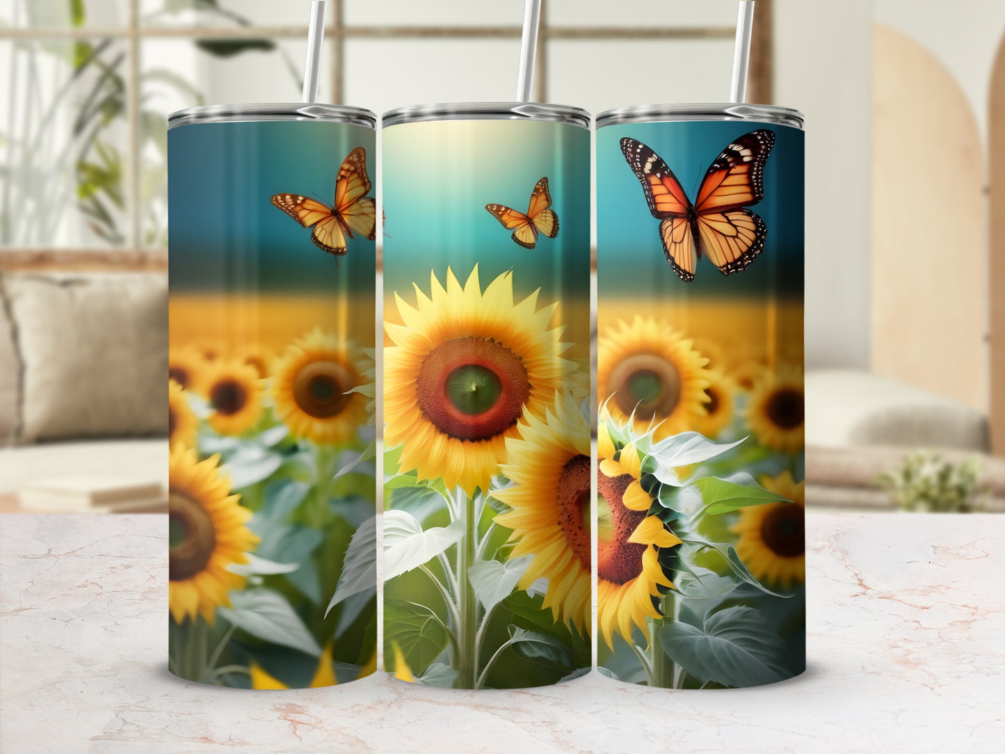 Three tumblers with sunflowers and butterflies, blurred sunflower field background.
