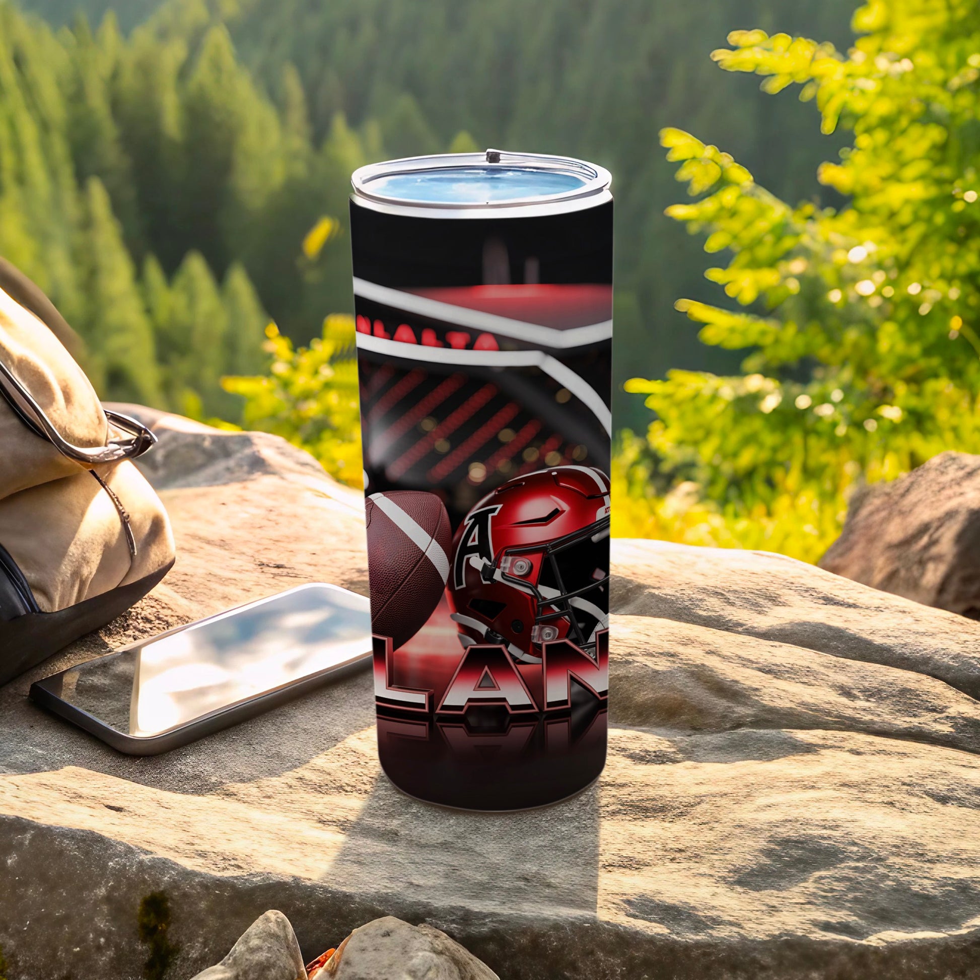 Tumbler featuring a football helmet and "LAN" text, resting on rocks.