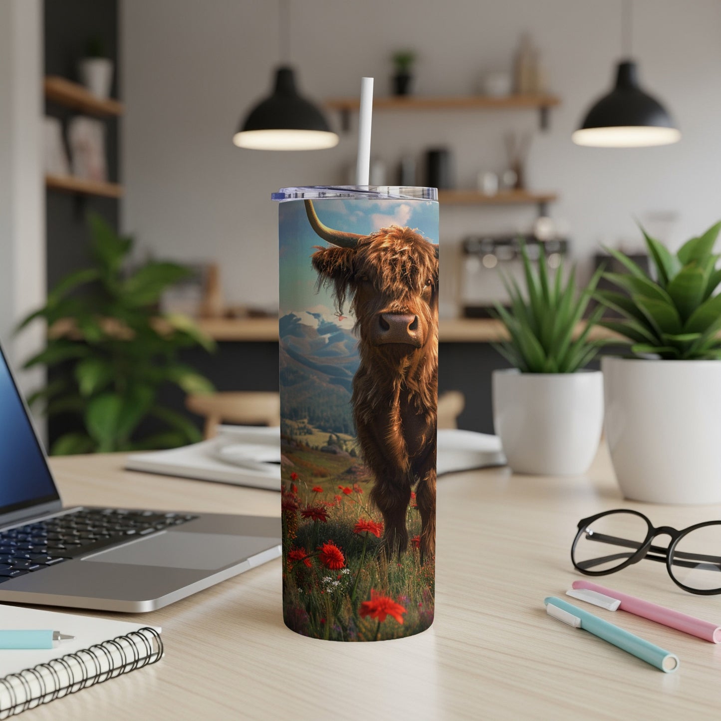 Highland cow standing in a field of red flowers on a tall tumbler.