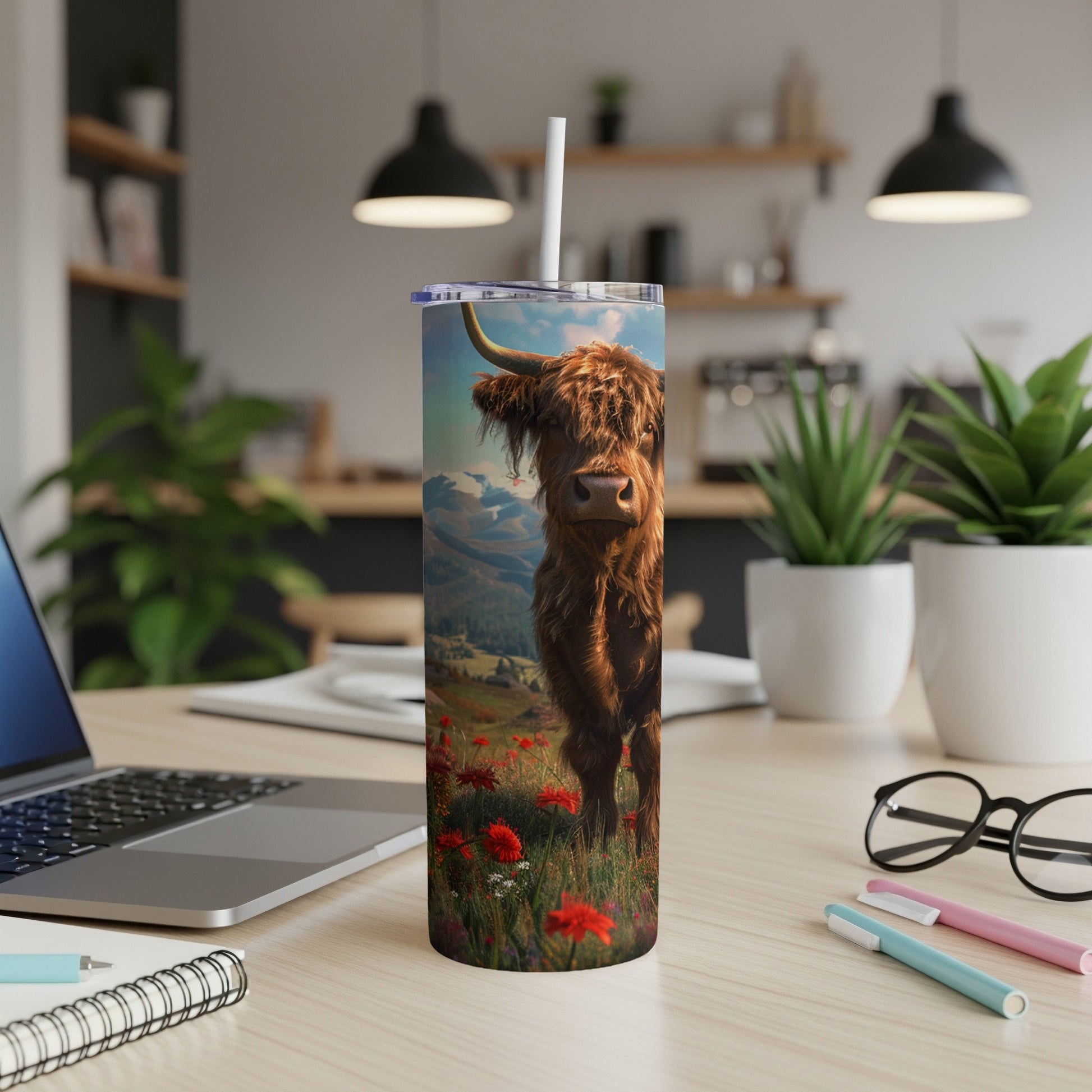 Highland cow standing in a field of red flowers on a tall tumbler.