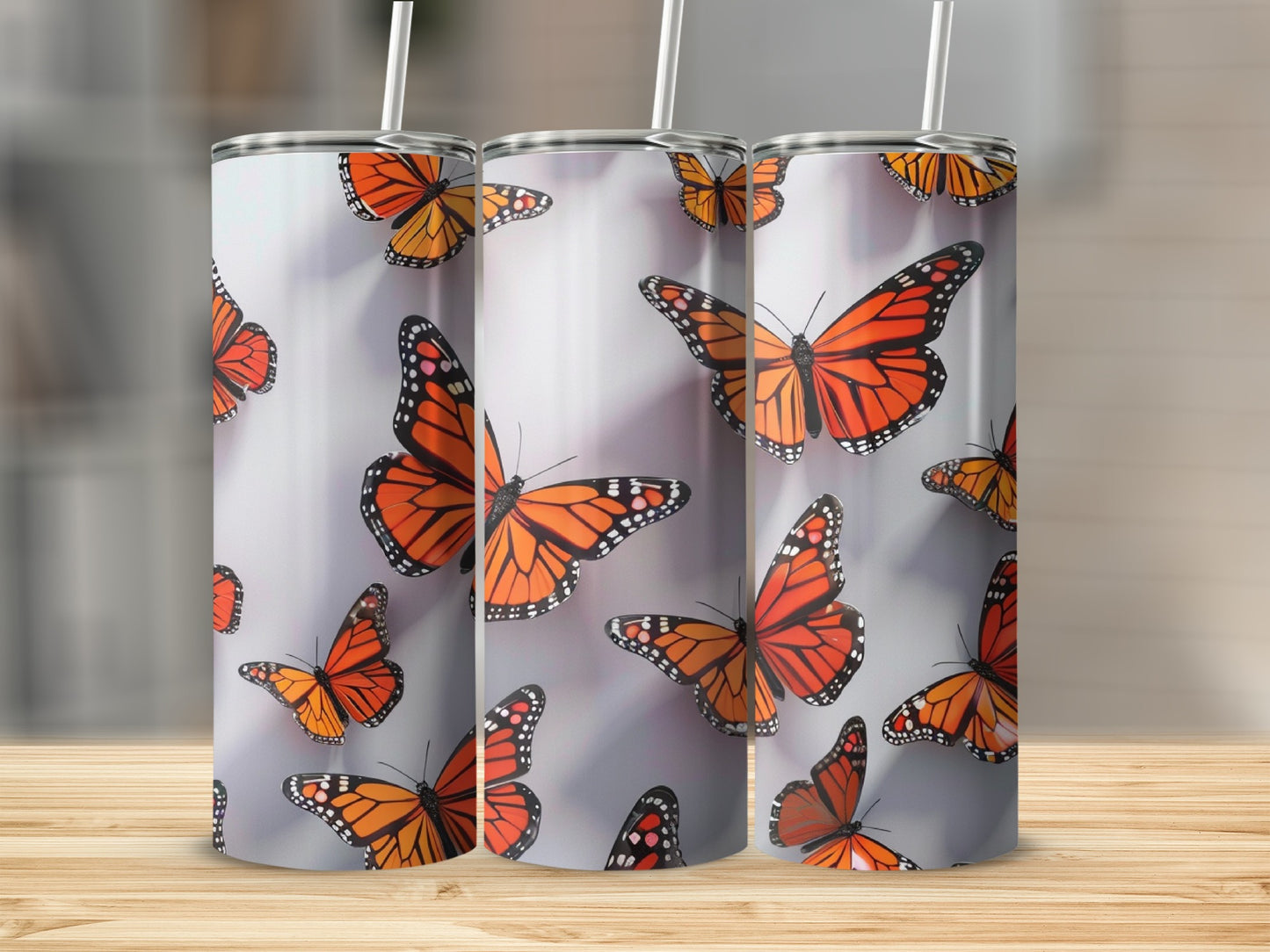 Three tumblers with a repeating pattern of orange monarch butterflies.