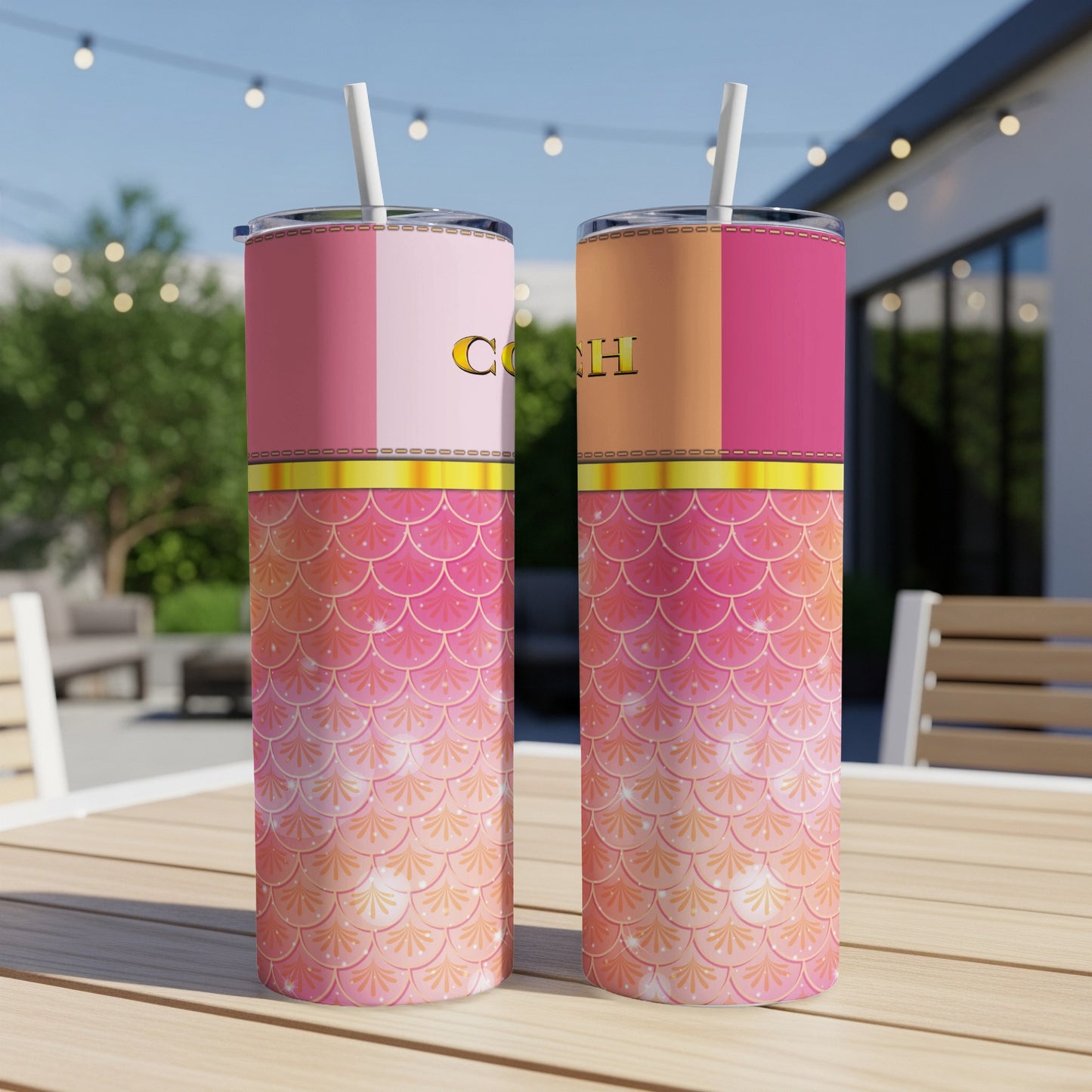 Two pink and orange mermaid scale tumblers with straws sitting on a wooden table.
