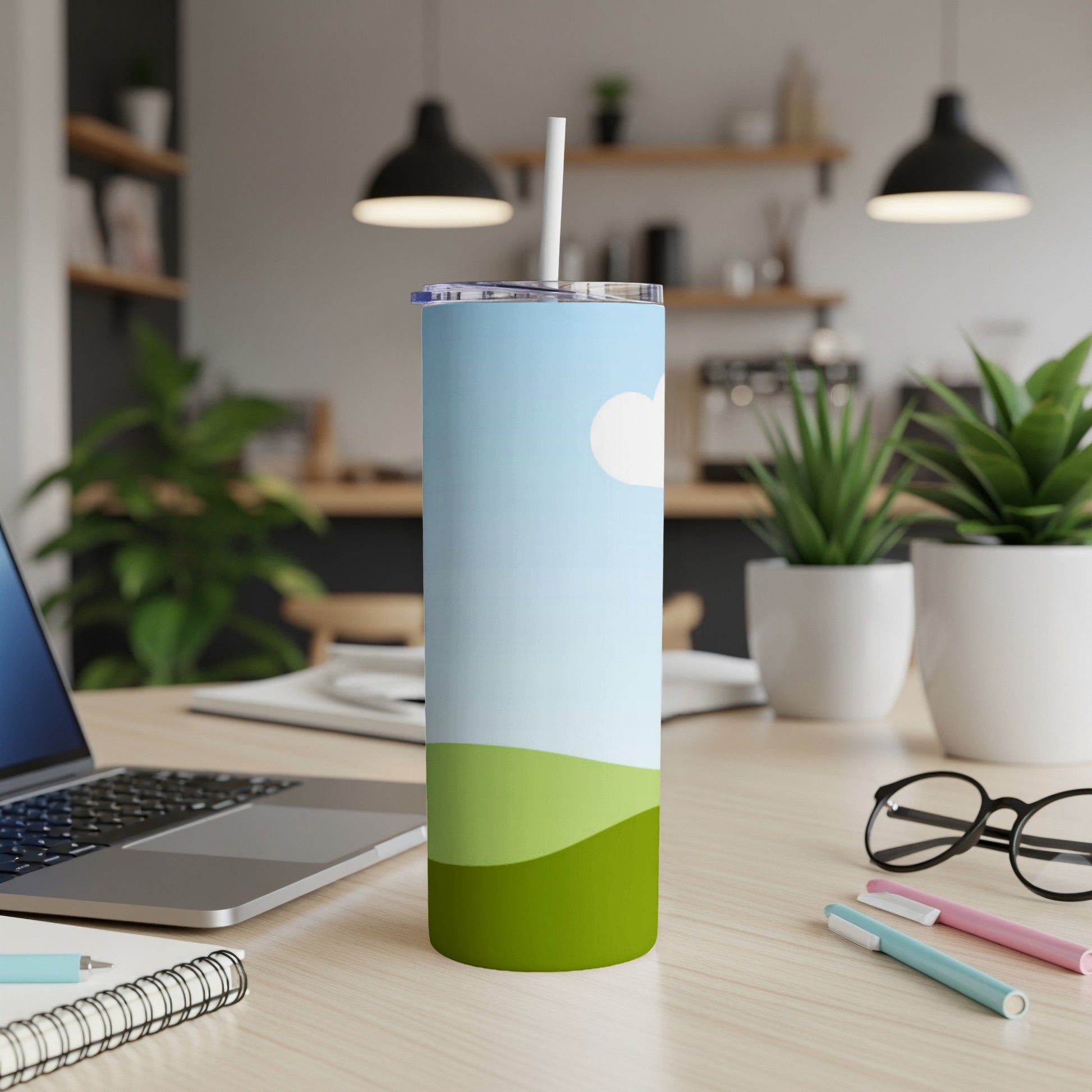 Blue and green landscape design on a white tumbler with a straw.