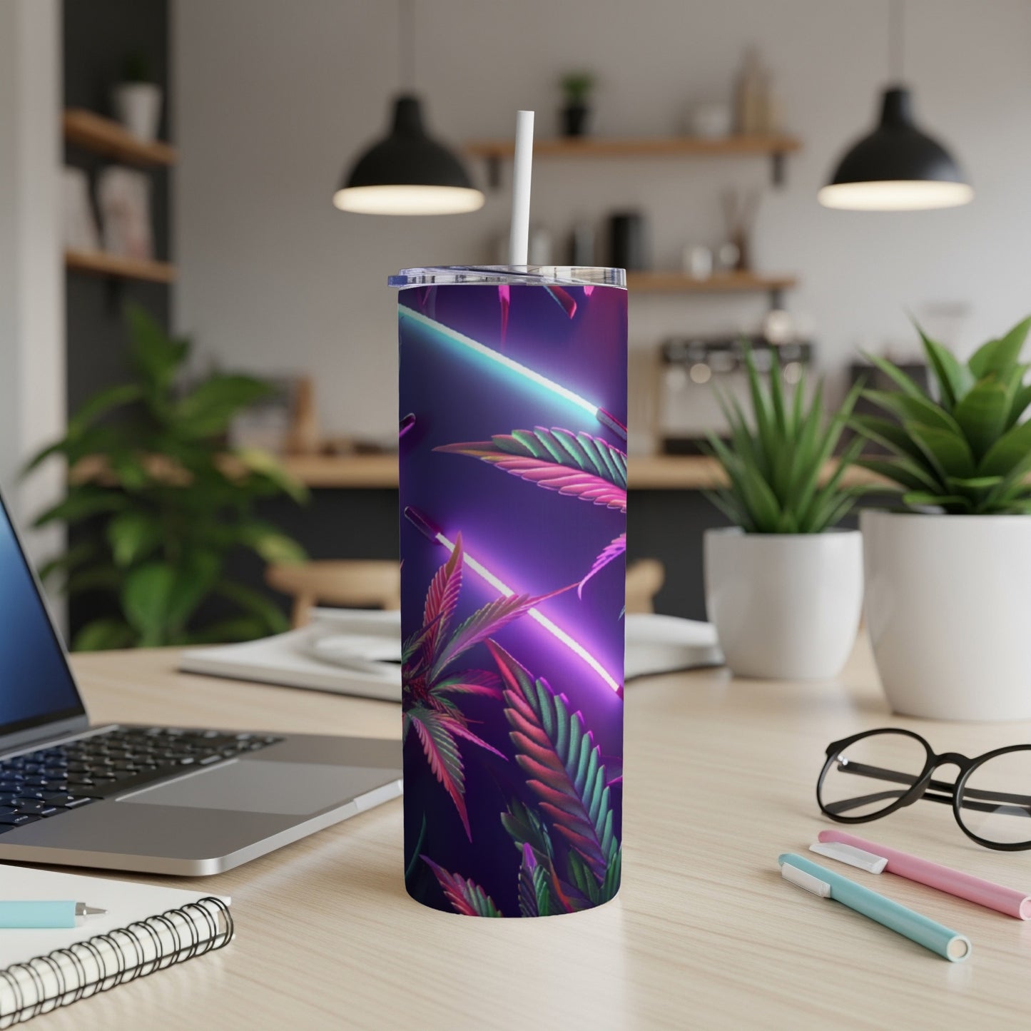 Neon cannabis leaves on a dark purple tumbler with a straw on a desk.