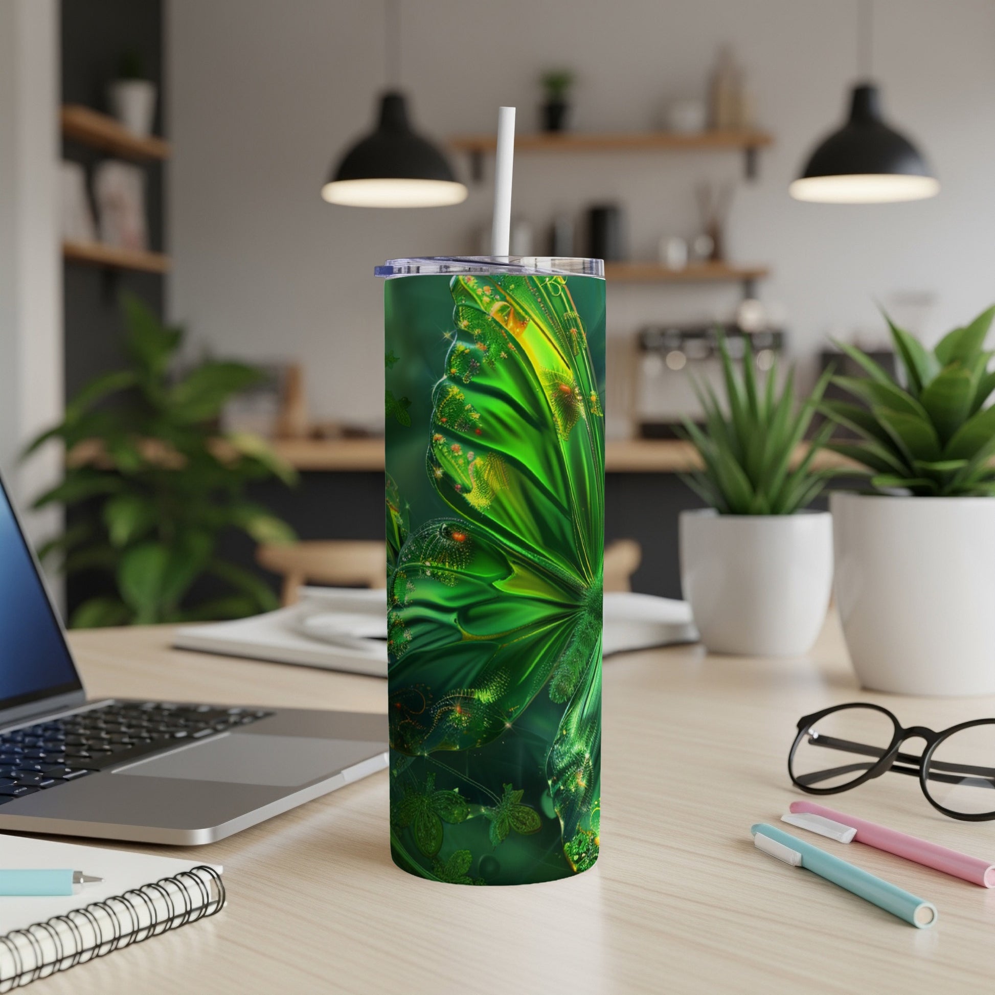 Green metallic butterfly tumbler with a straw on a desk.