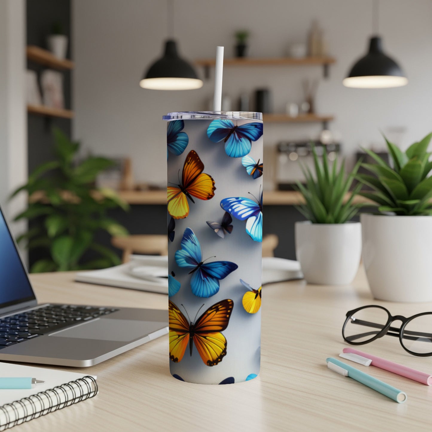 White tumbler with colorful butterflies and a straw on a desk.