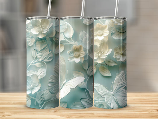 Three tumblers with embossed white flowers and butterflies on a teal background.