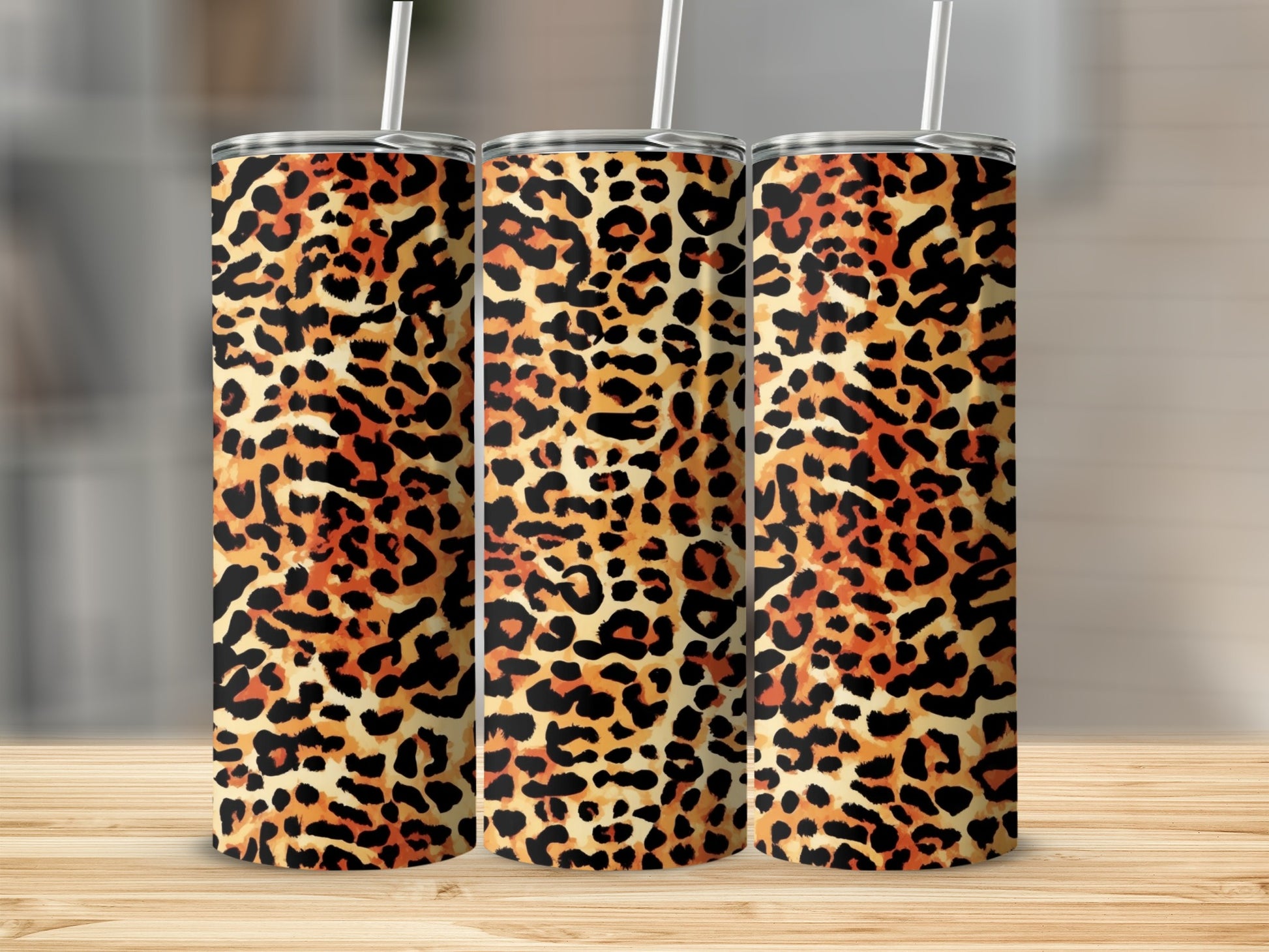 Three tumblers with a leopard print design and white straws.