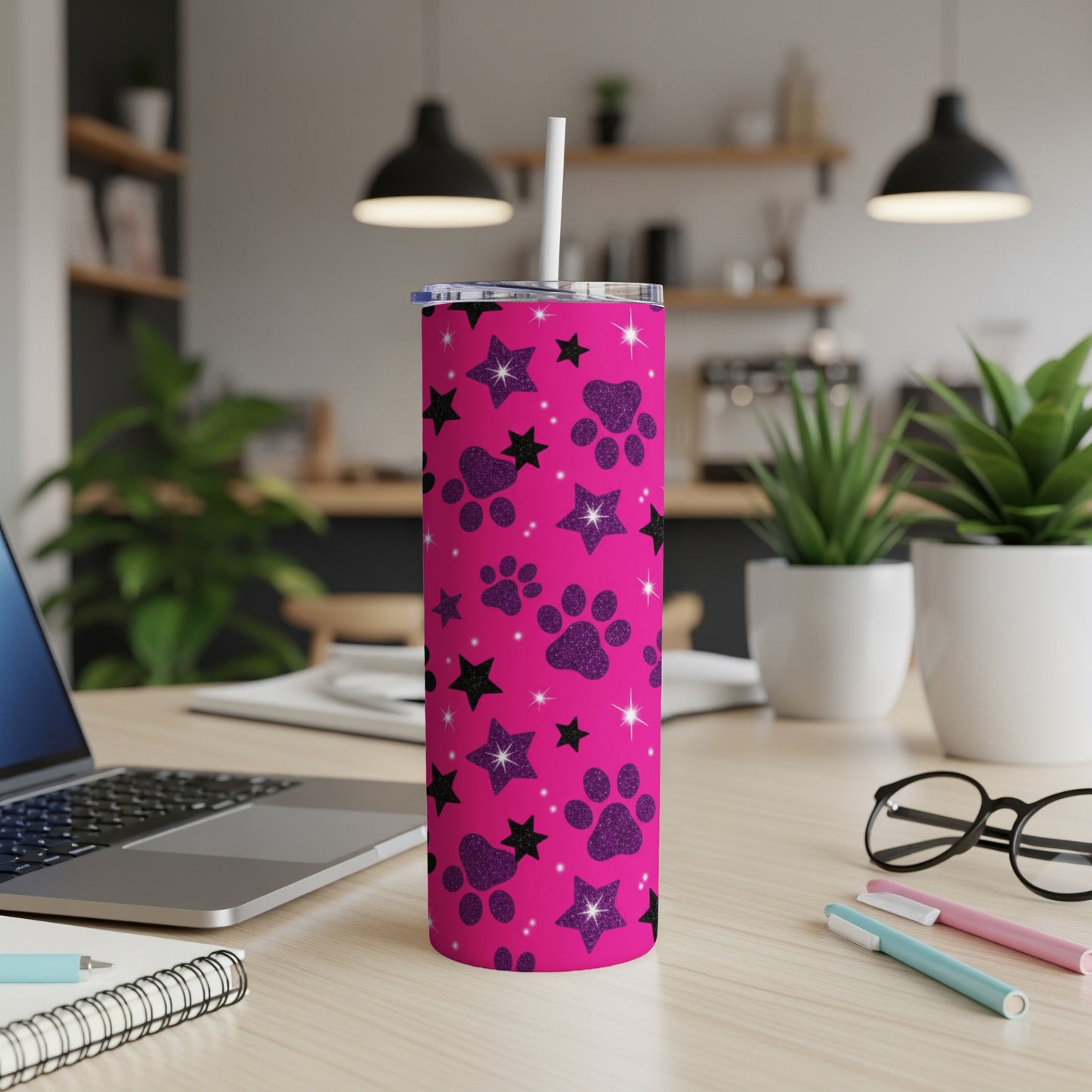 Pink tumbler with black paw prints and stars, includes straw.