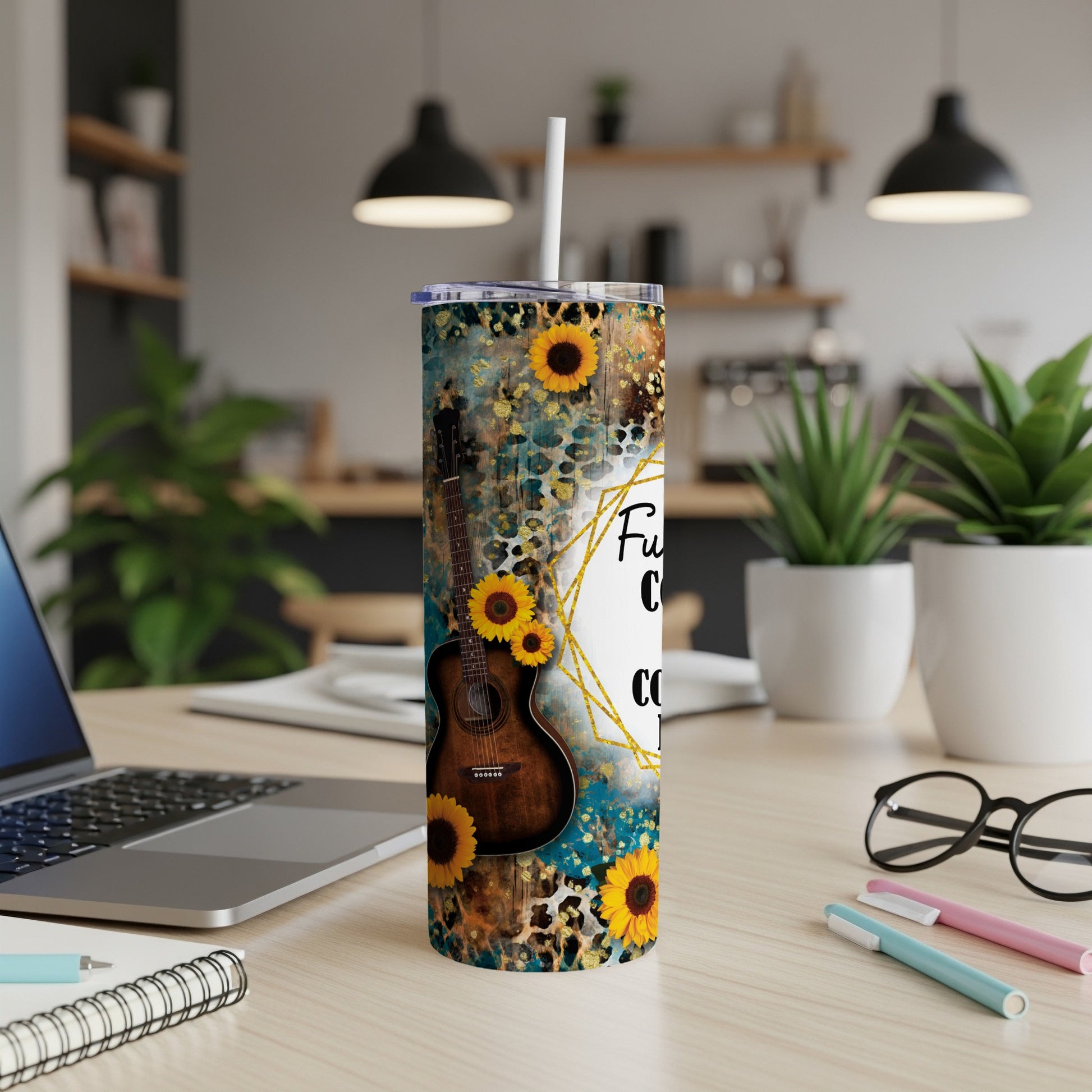 Acoustic guitar and sunflowers on a teal marble tumbler with white lid and straw.