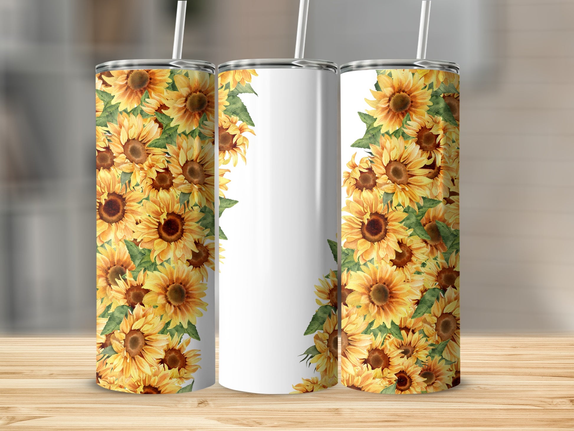 Three white tumblers decorated with a pattern of sunflowers against a wooden surface.