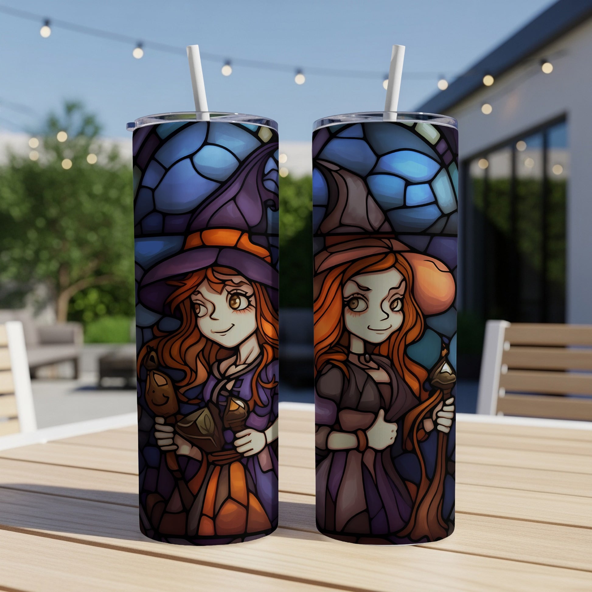 Two stained-glass style witch tumblers with straws on a table.