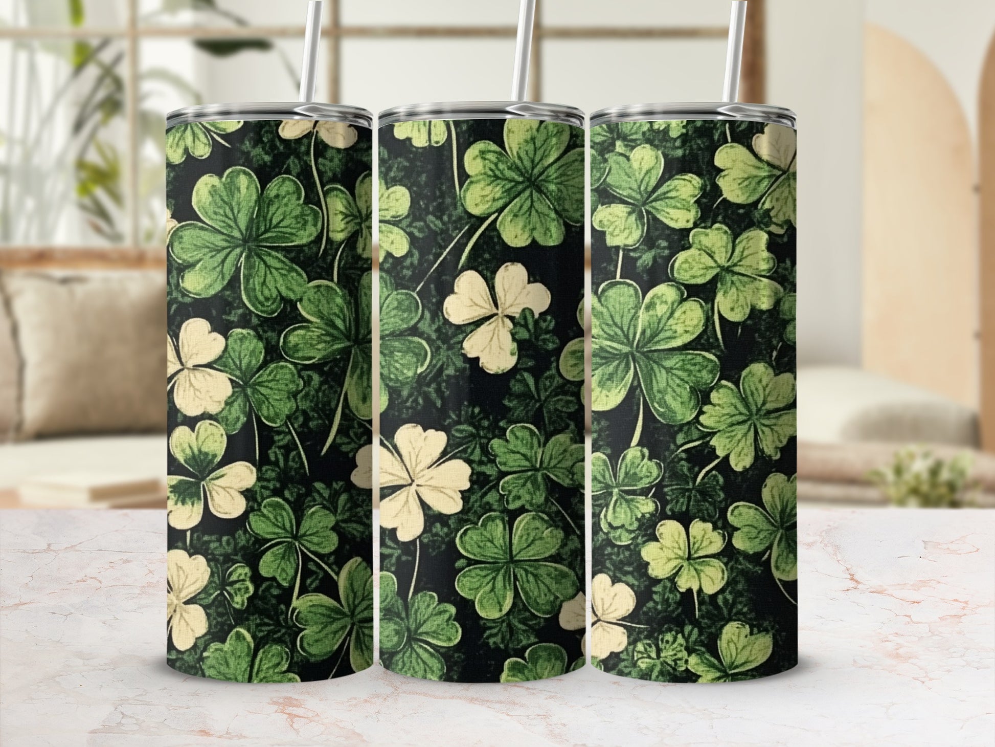 Green and cream shamrock pattern on three black tumblers with straws.
