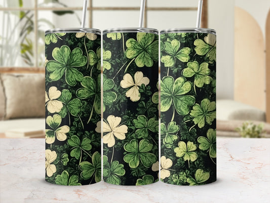 Green and cream shamrock pattern on three black tumblers with straws.