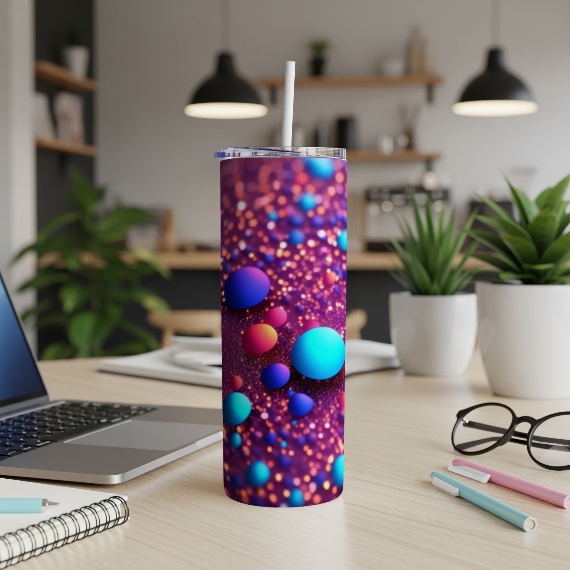 Tumbler with colorful bubbles and glitter design on a desk.