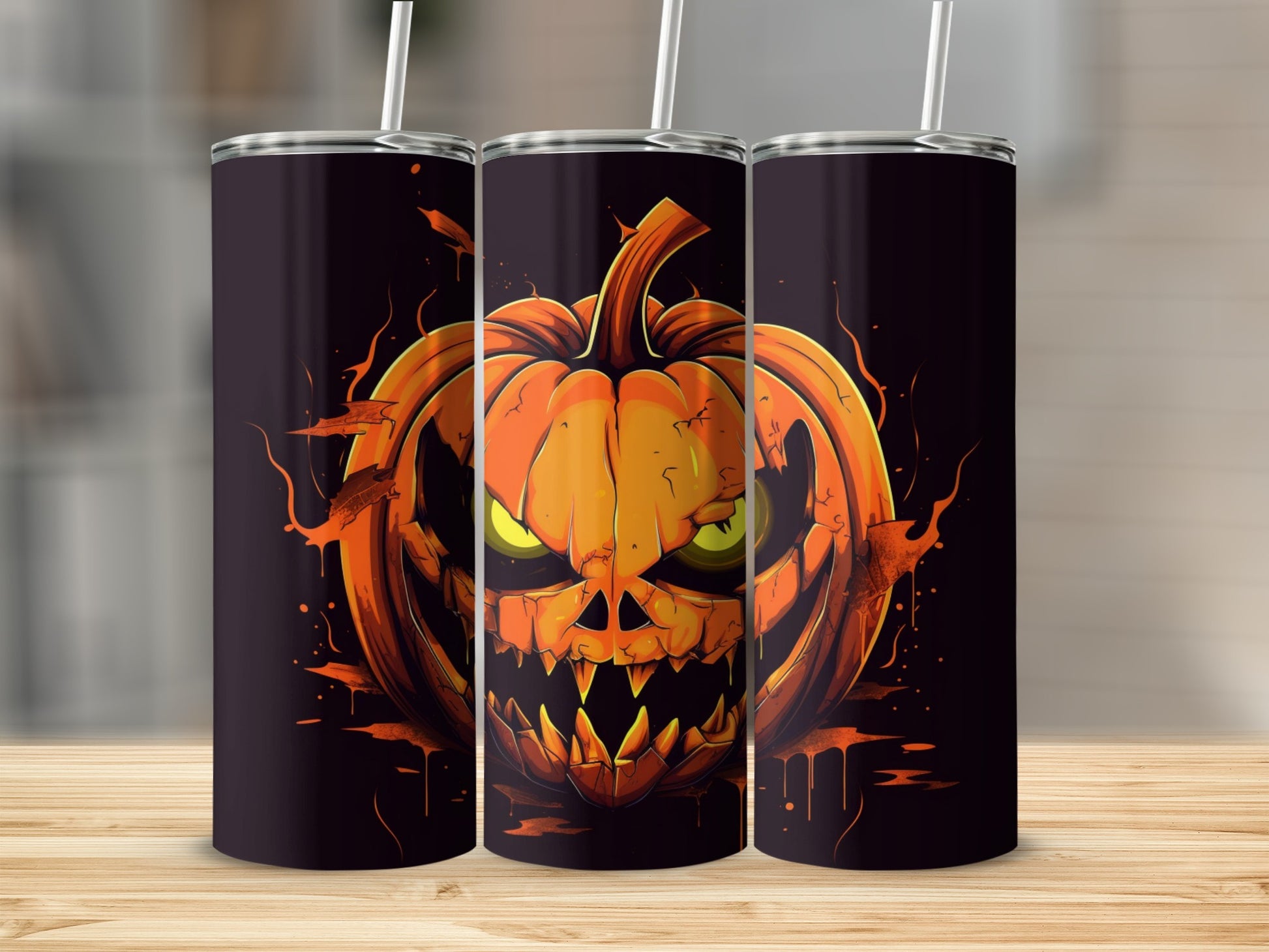 Three tumblers with a spooky jack-o'-lantern design and straws.