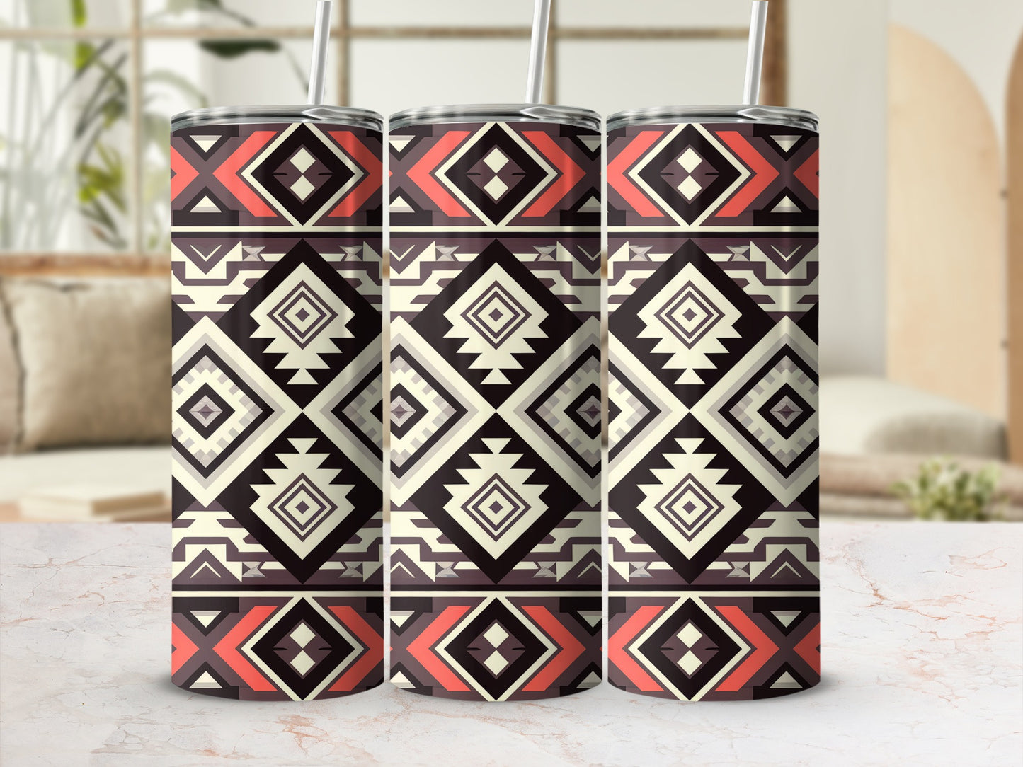 Three tumblers with a geometric tribal pattern and straws on a counter.
